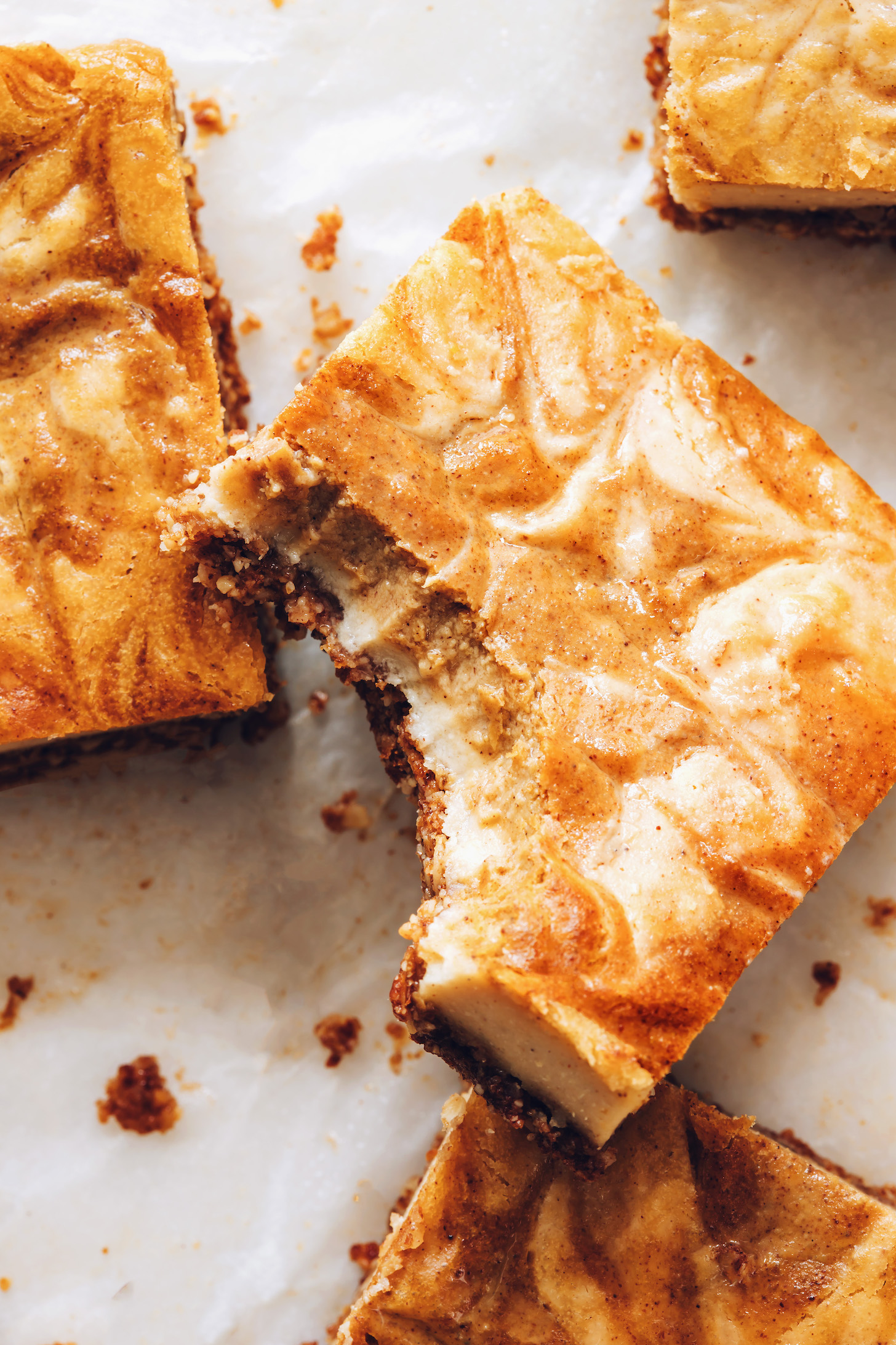 Showing the creamy texture inside a partially eaten pumpkin cheesecake bar