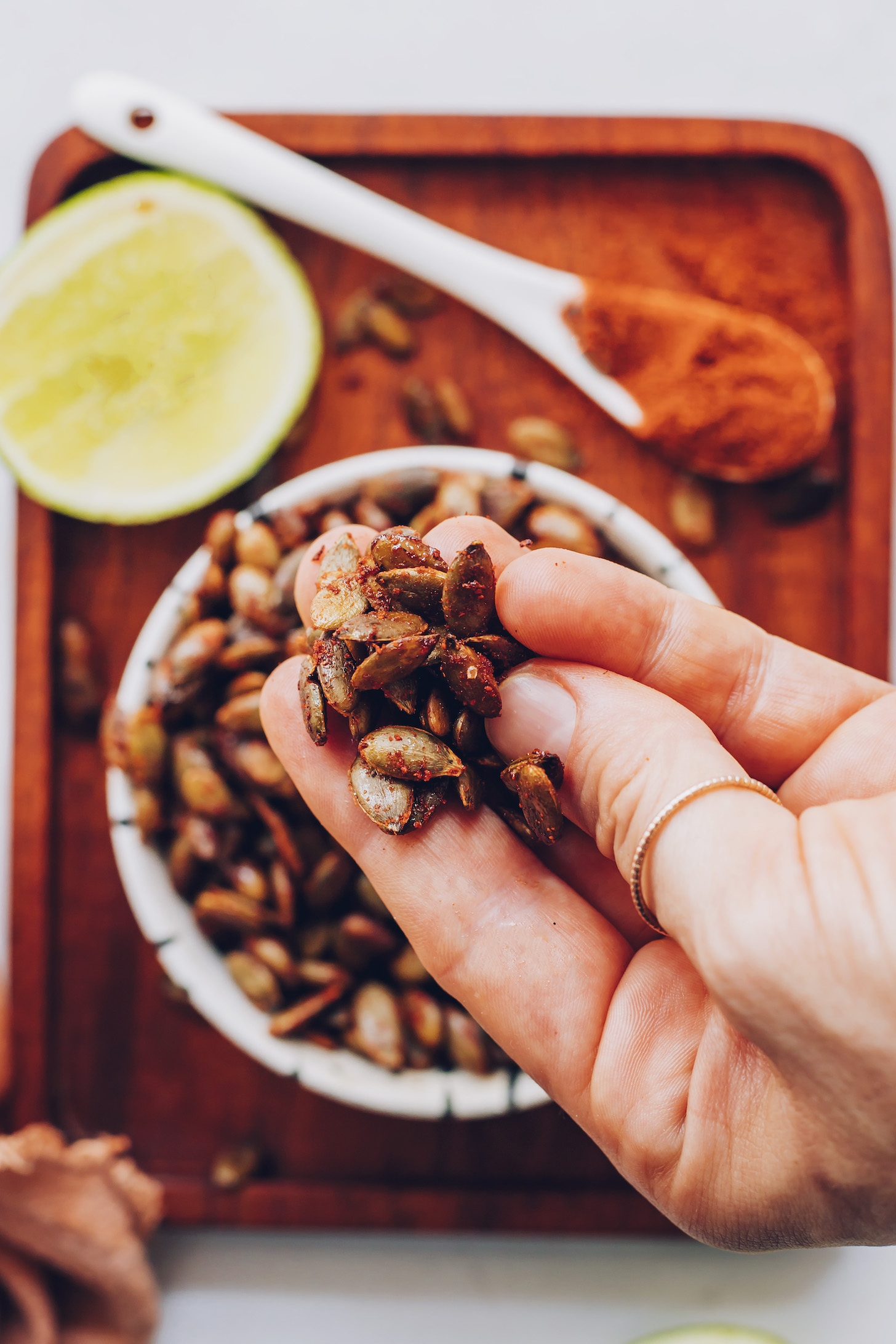 Holding a cluster of roasted pepitas coated with spices