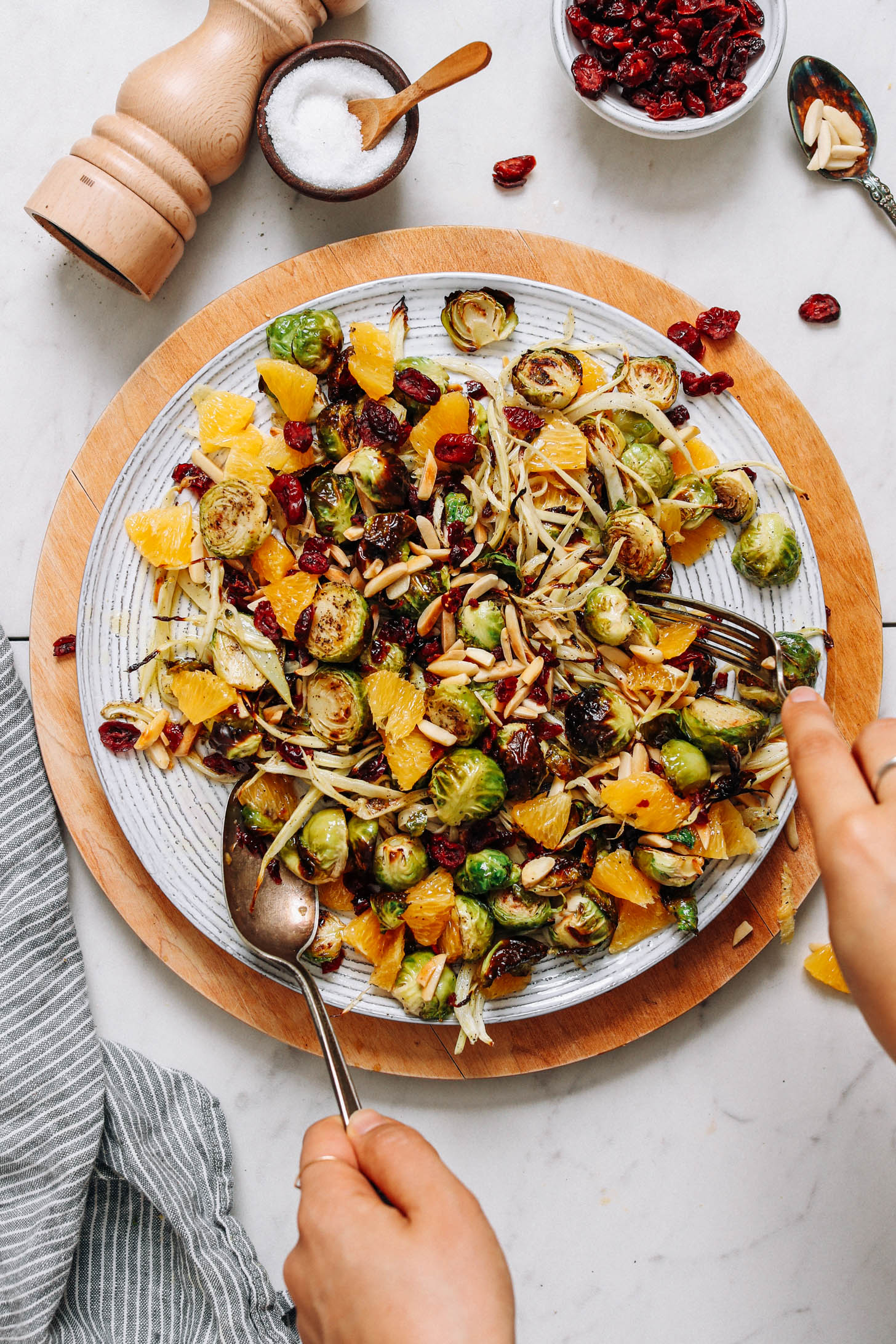 Tossing a platter of salad with apple cider vinegar dressing
