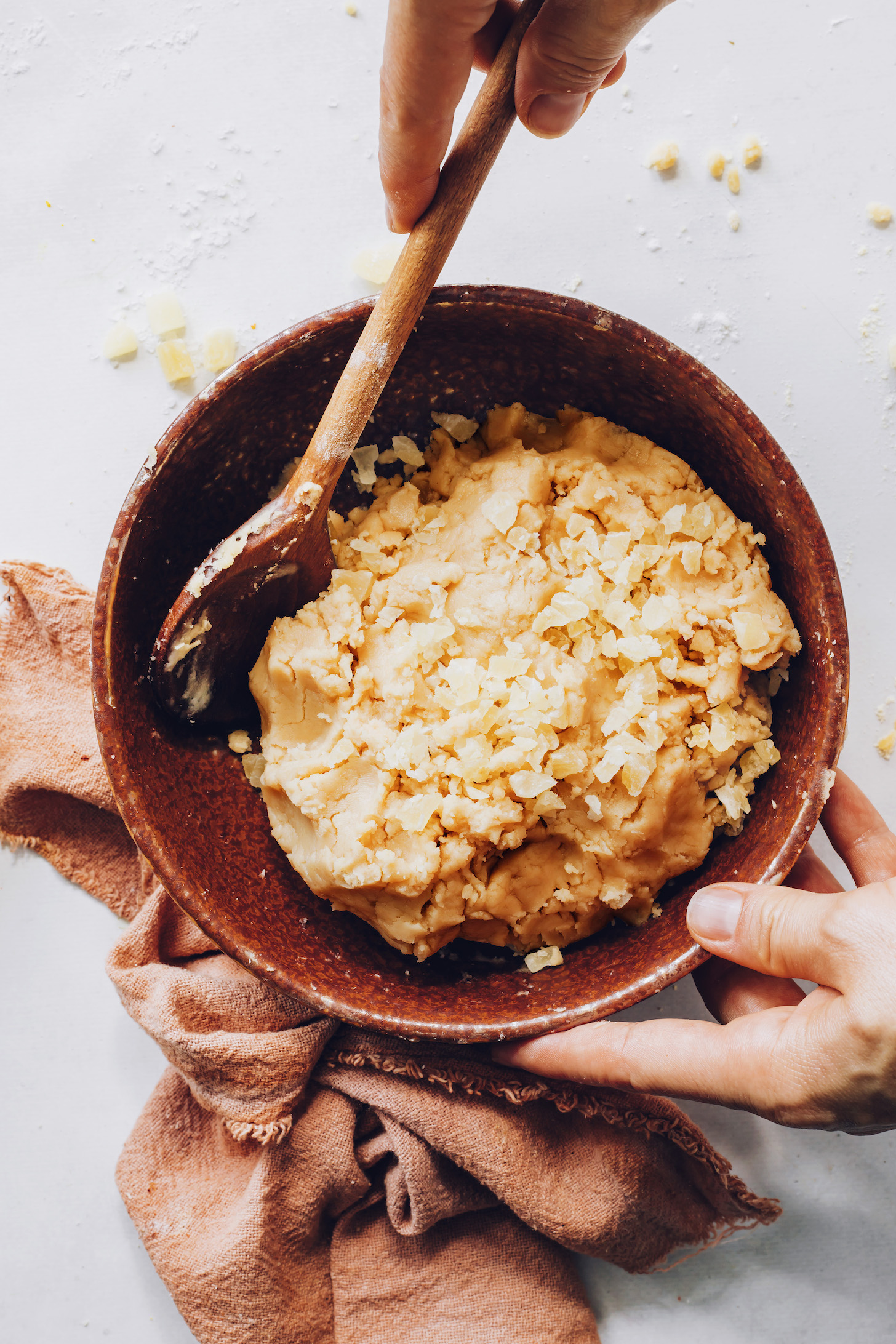 Bowl of gluten-free biscotti dough topped with chopped candied ginger