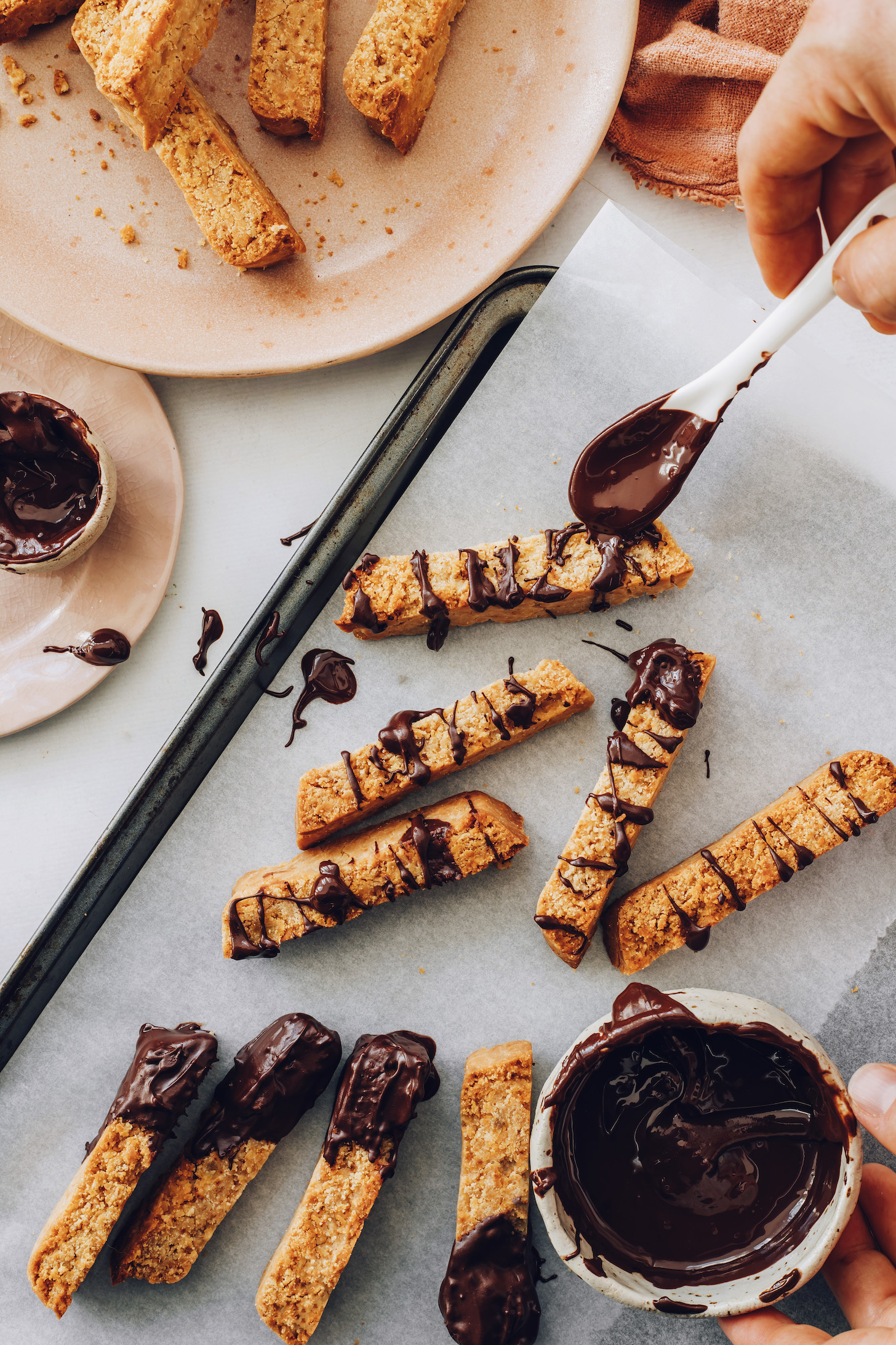 Drizzling gluten-free biscotti with melted chocolate