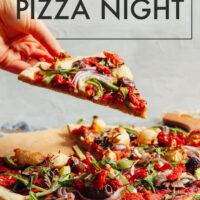 Hand picking up a piece of vegan and gluten-free cauliflower crust pizza