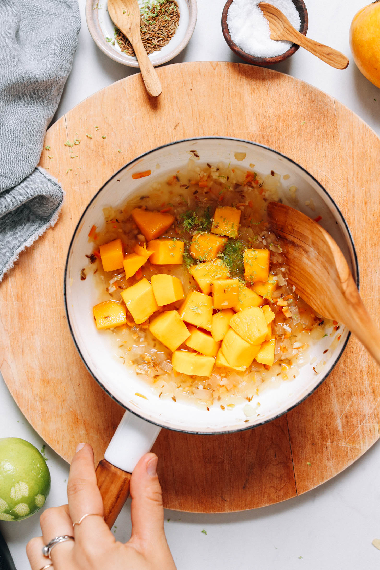 Saucepan of mango, sautéed onion, cumin seeds, lime zest, lime juice, water, and vinegar