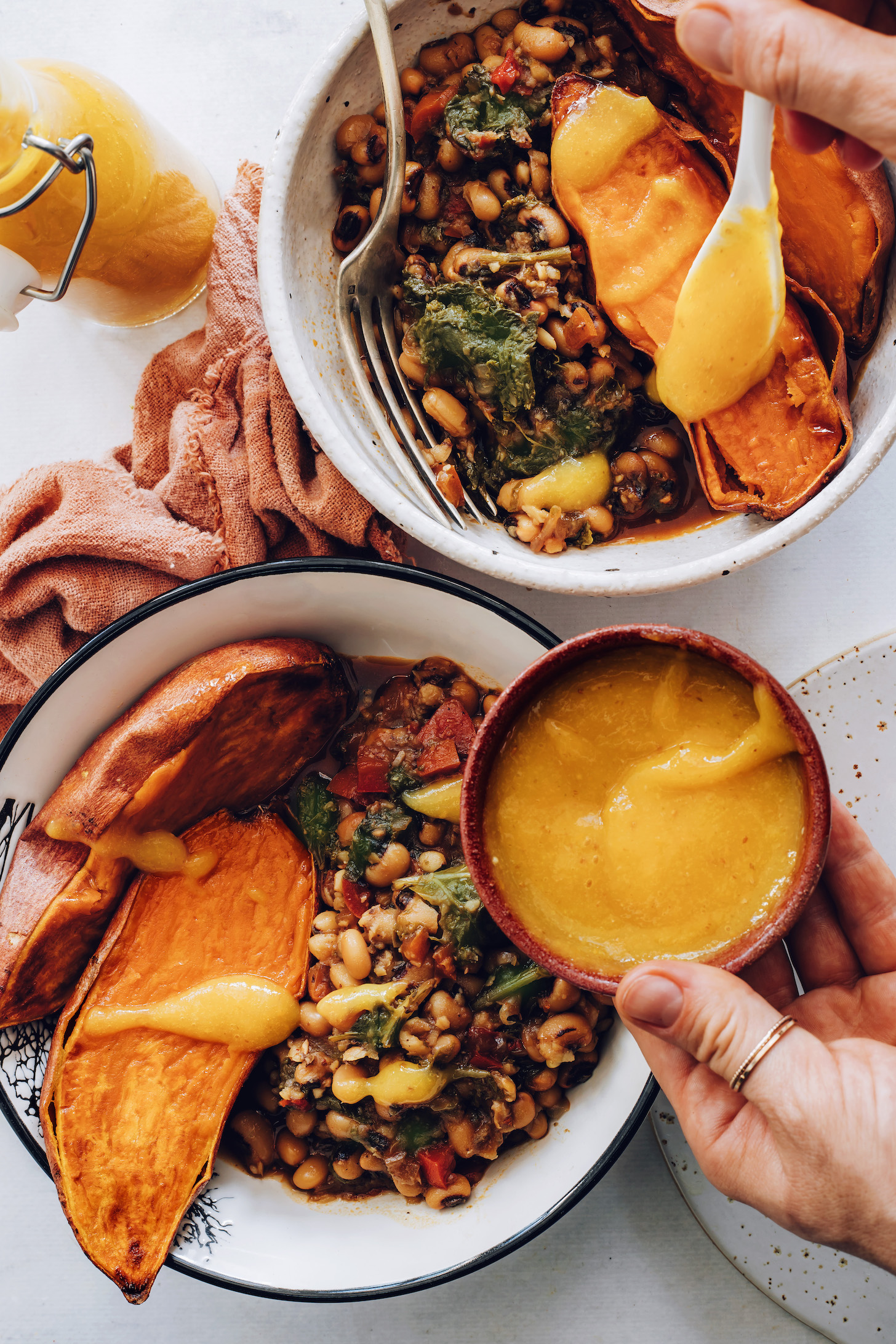 Adding hot sauce to sweet potato nourish bowls