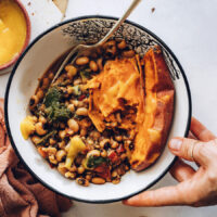 Holding a nourish bowl topped with mango hot sauce