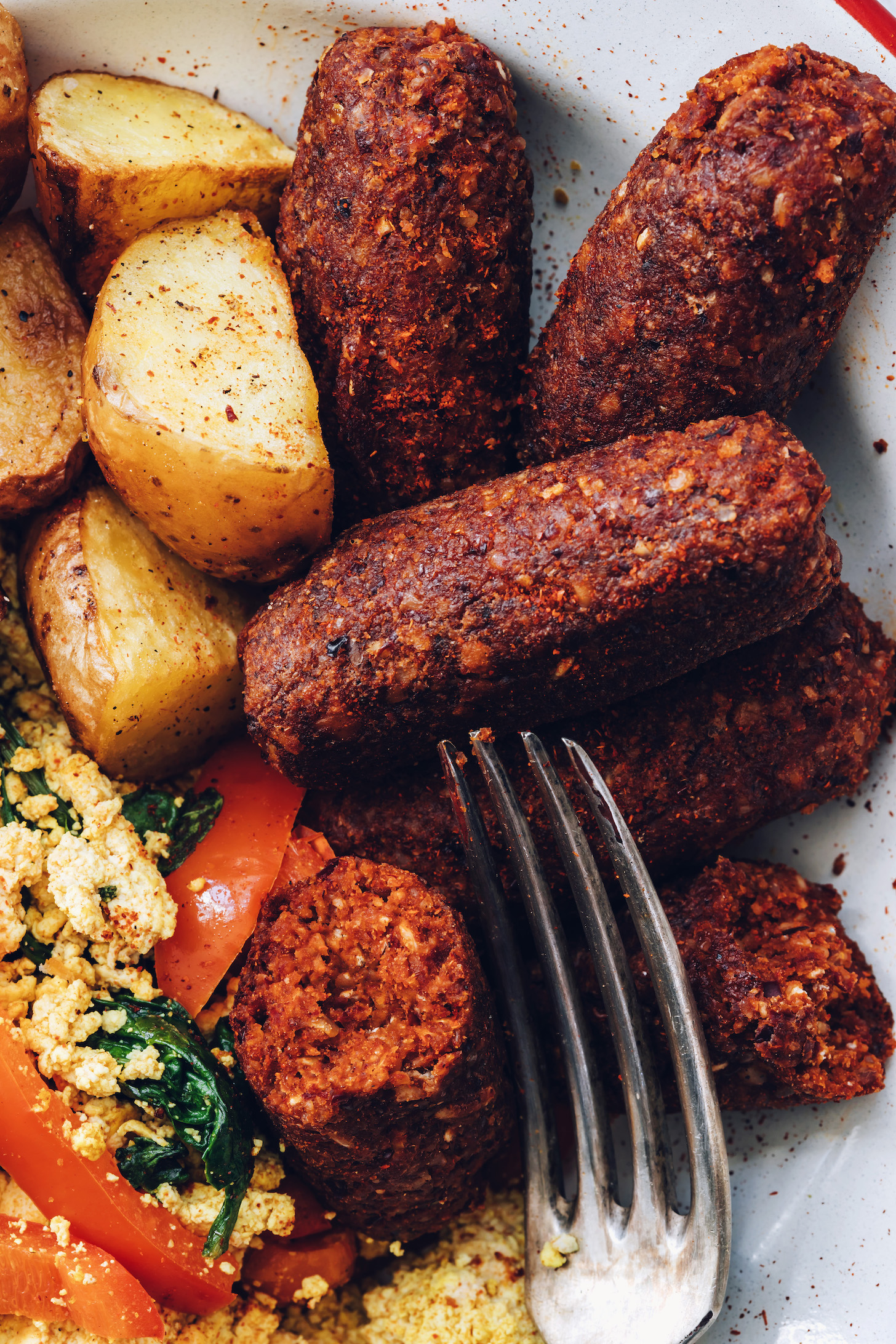 Close-up shot of slicing into a vegan chorizo sausage link