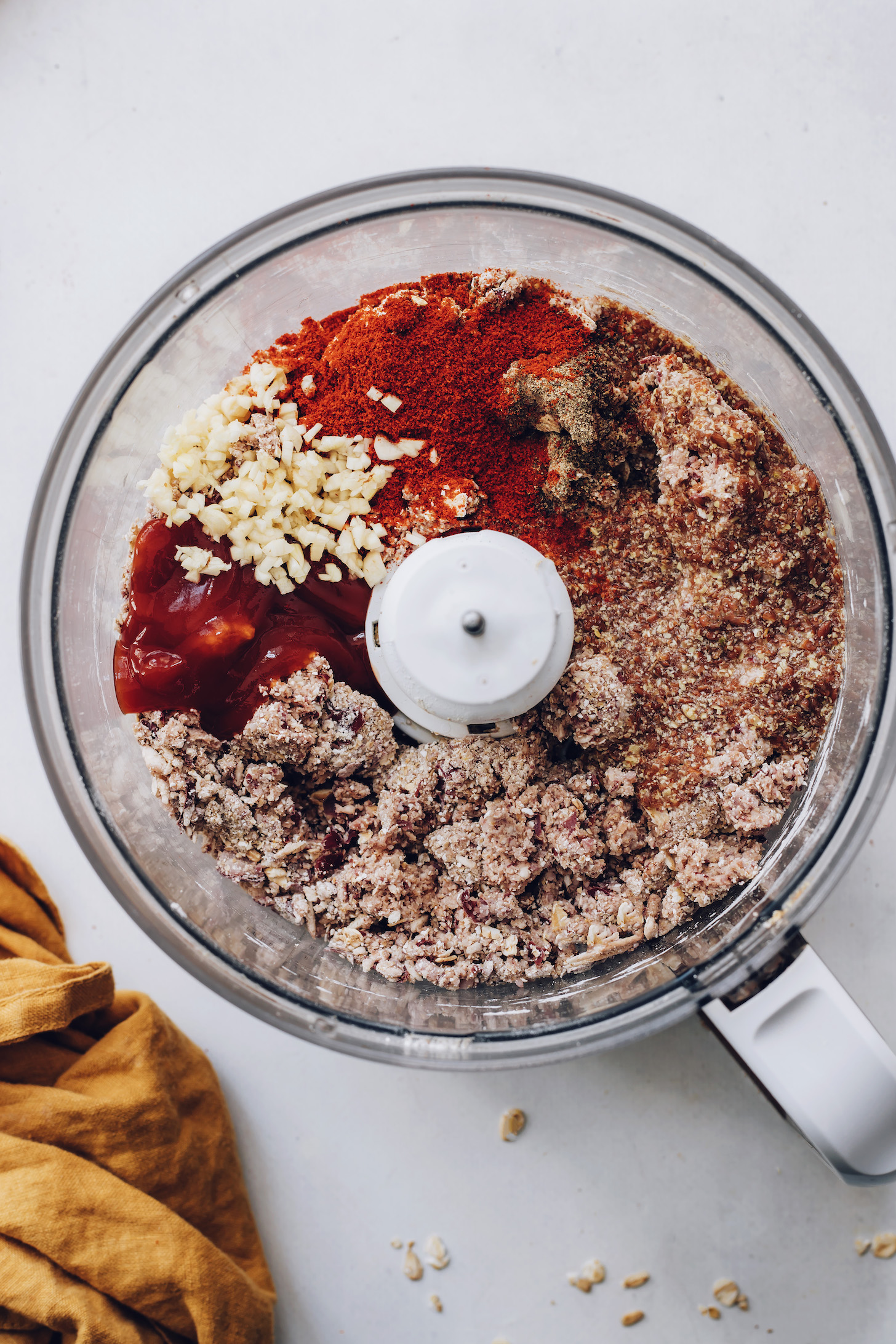 Ketchup, garlic, spices, and flax eggs in a bean, oat, and mushroom mixture