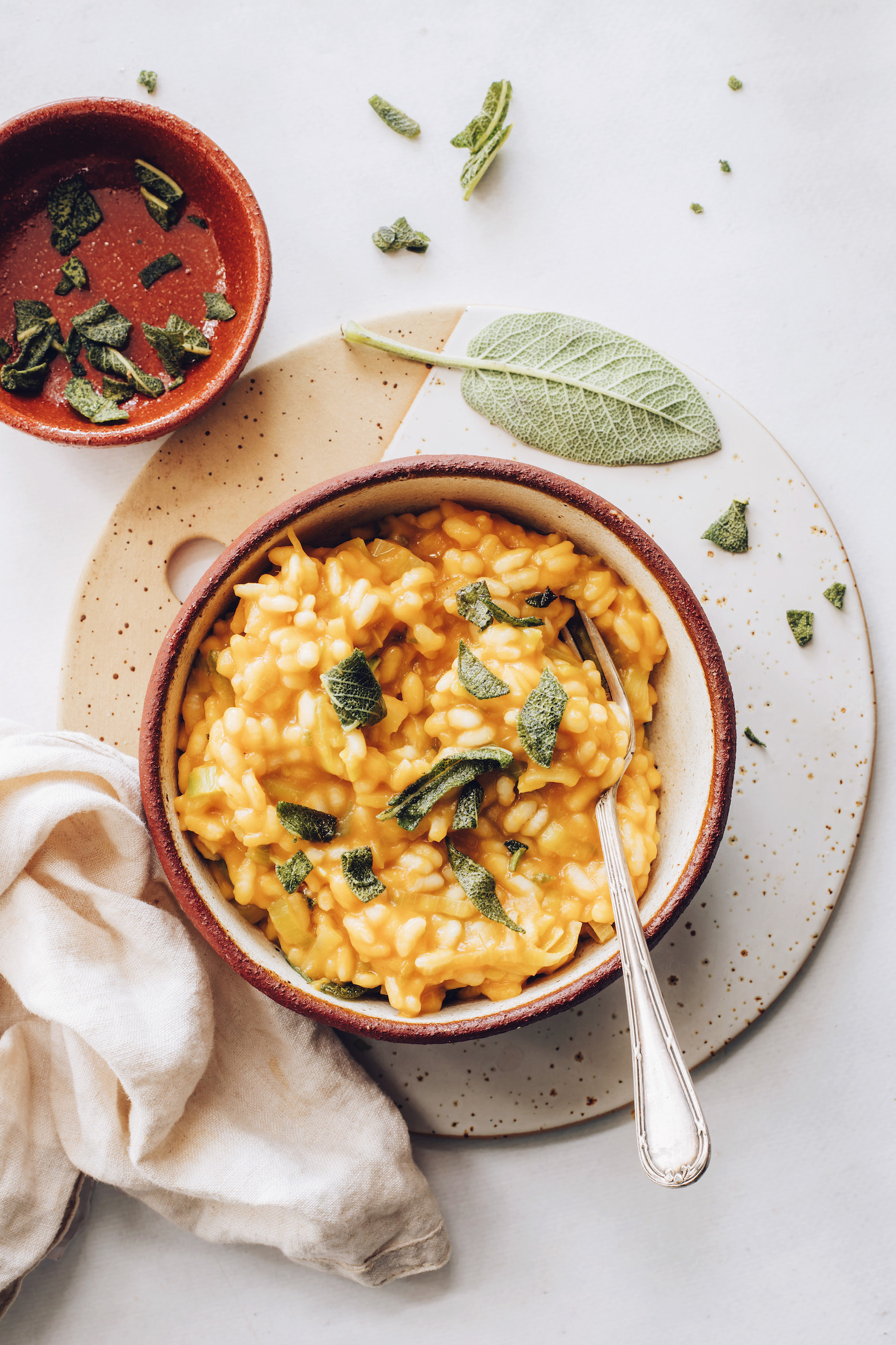 Bowl of crispy sage and bowl of pumpkin risotto with crispy sage