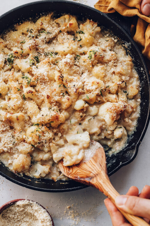 Wooden spoon in a pan of cauliflower au gratin