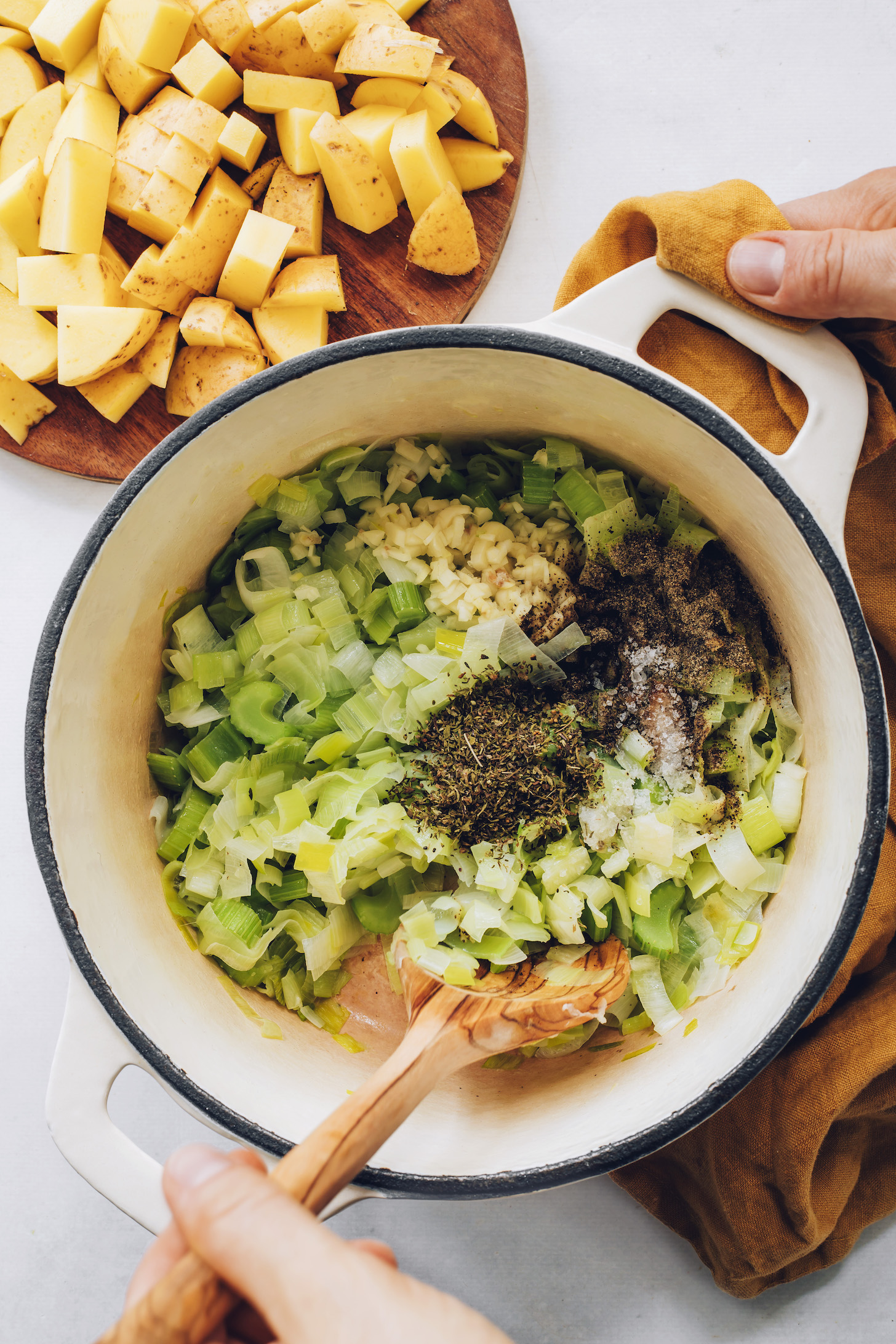 Sautéing leeks, celery, garlic, thyme, salt, and pepper
