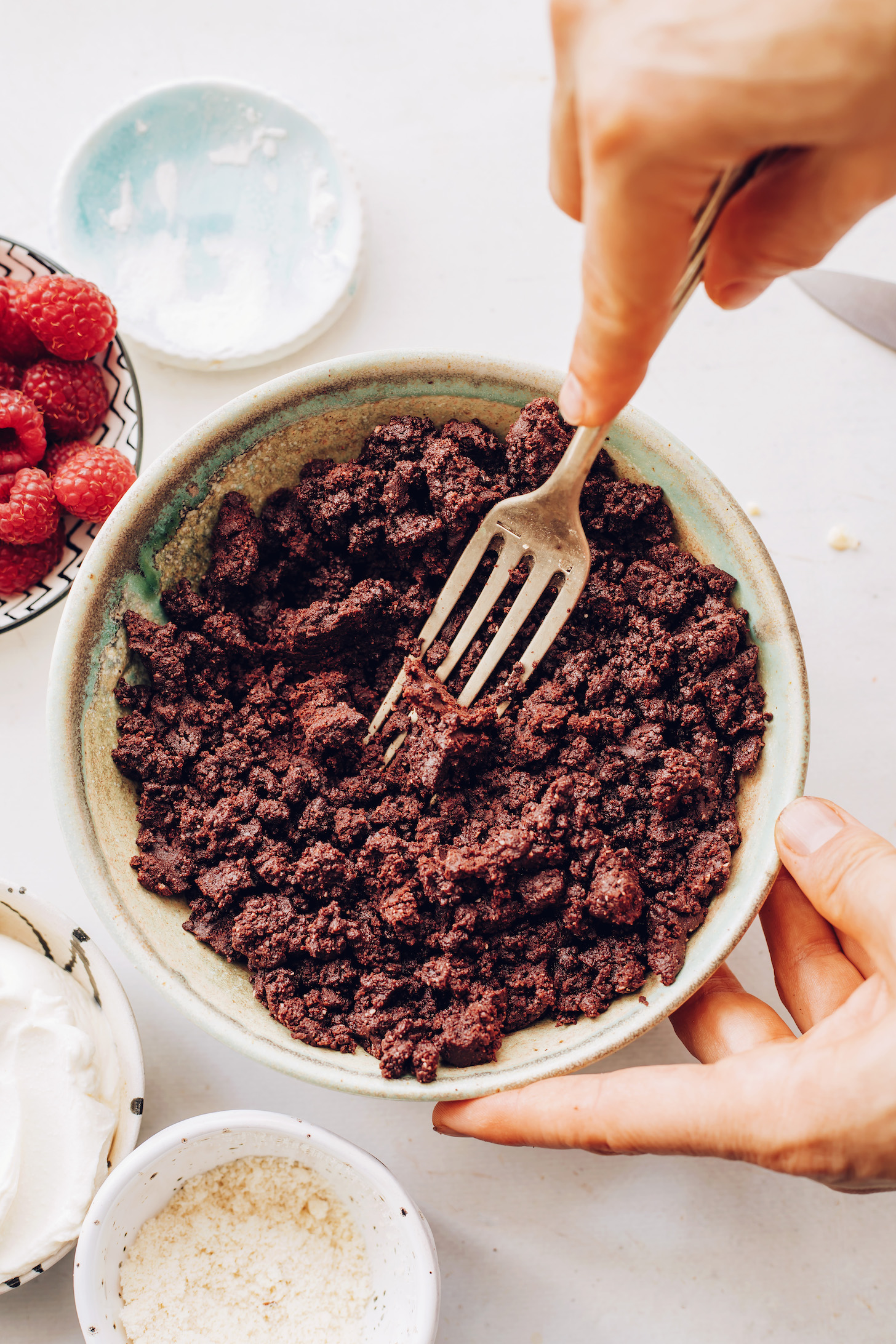 Using a fork to mix chocolate cookie cheesecake crust