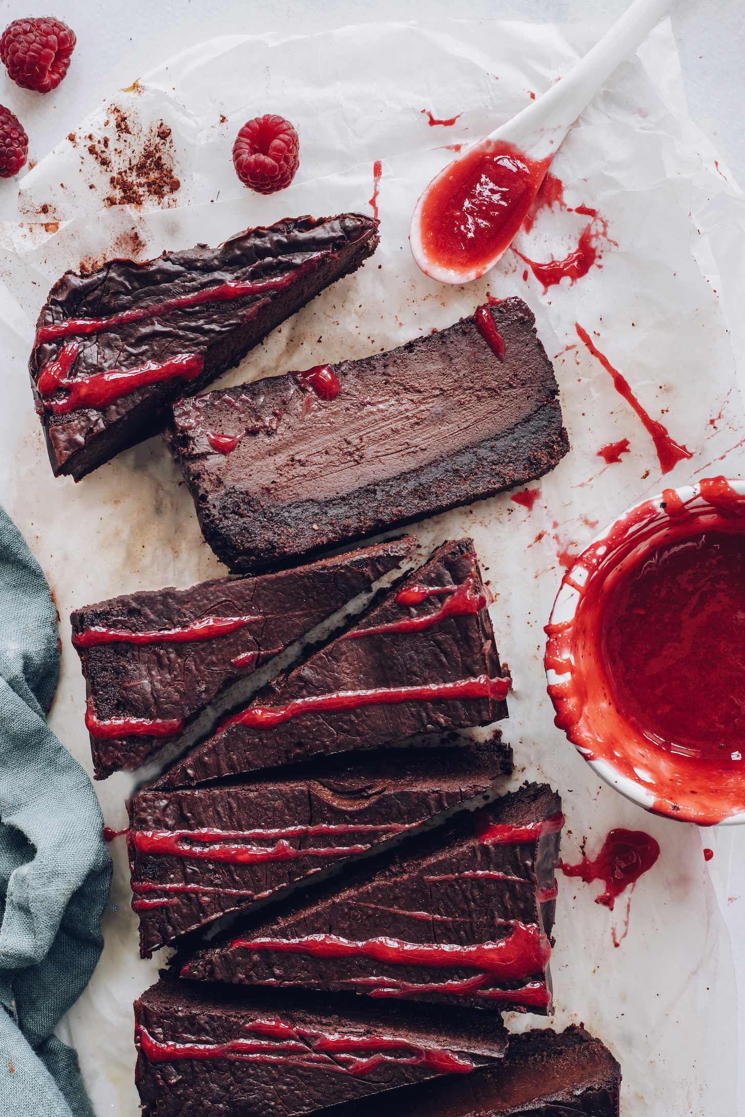 Raspberry sauce drizzled over slices of chocolate cheesecake