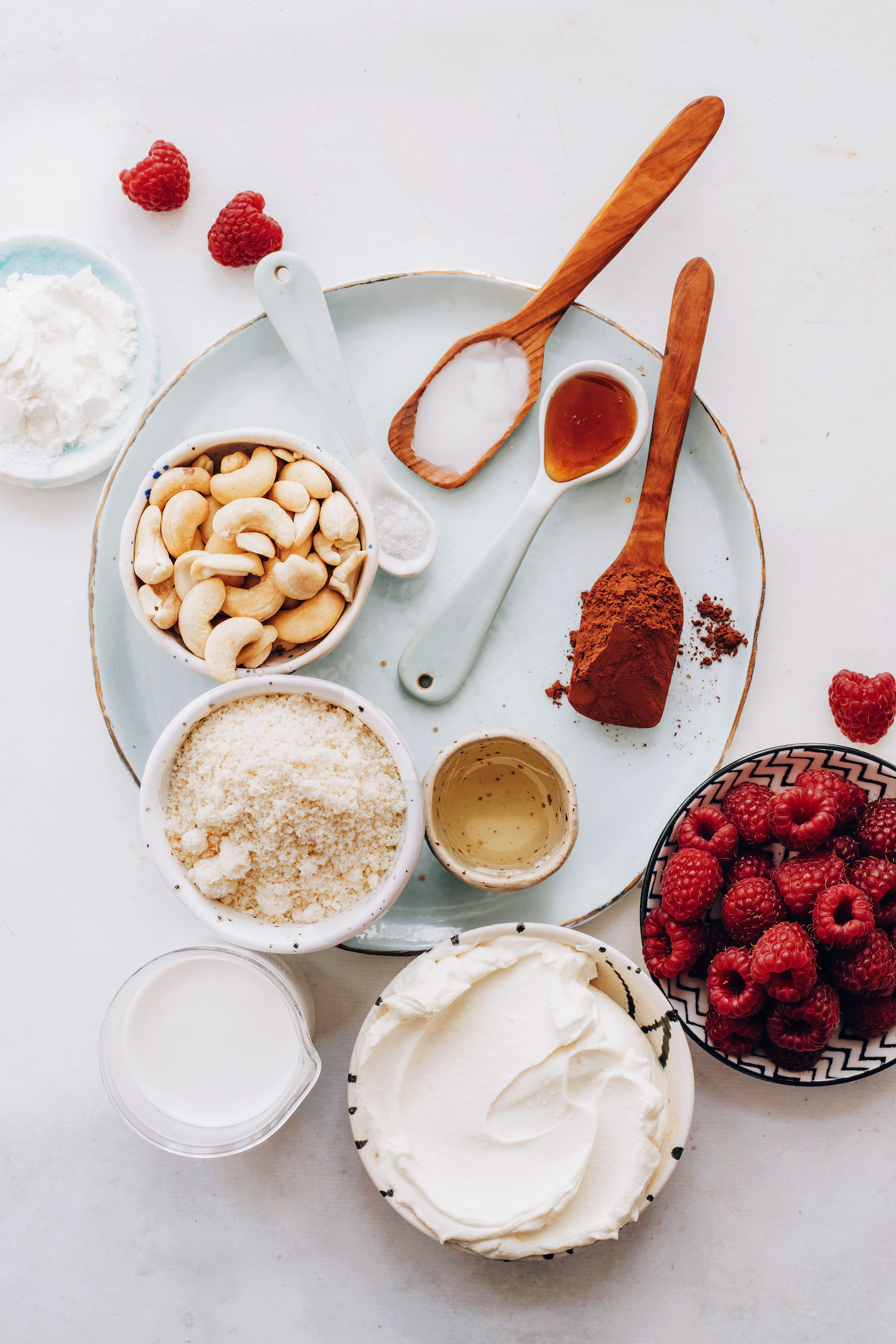 Cashews, salt, coconut oil, maple syrup, cocoa powder, arrowroot starch, almond flour, raspberries, vegan cream cheese, and coconut cream