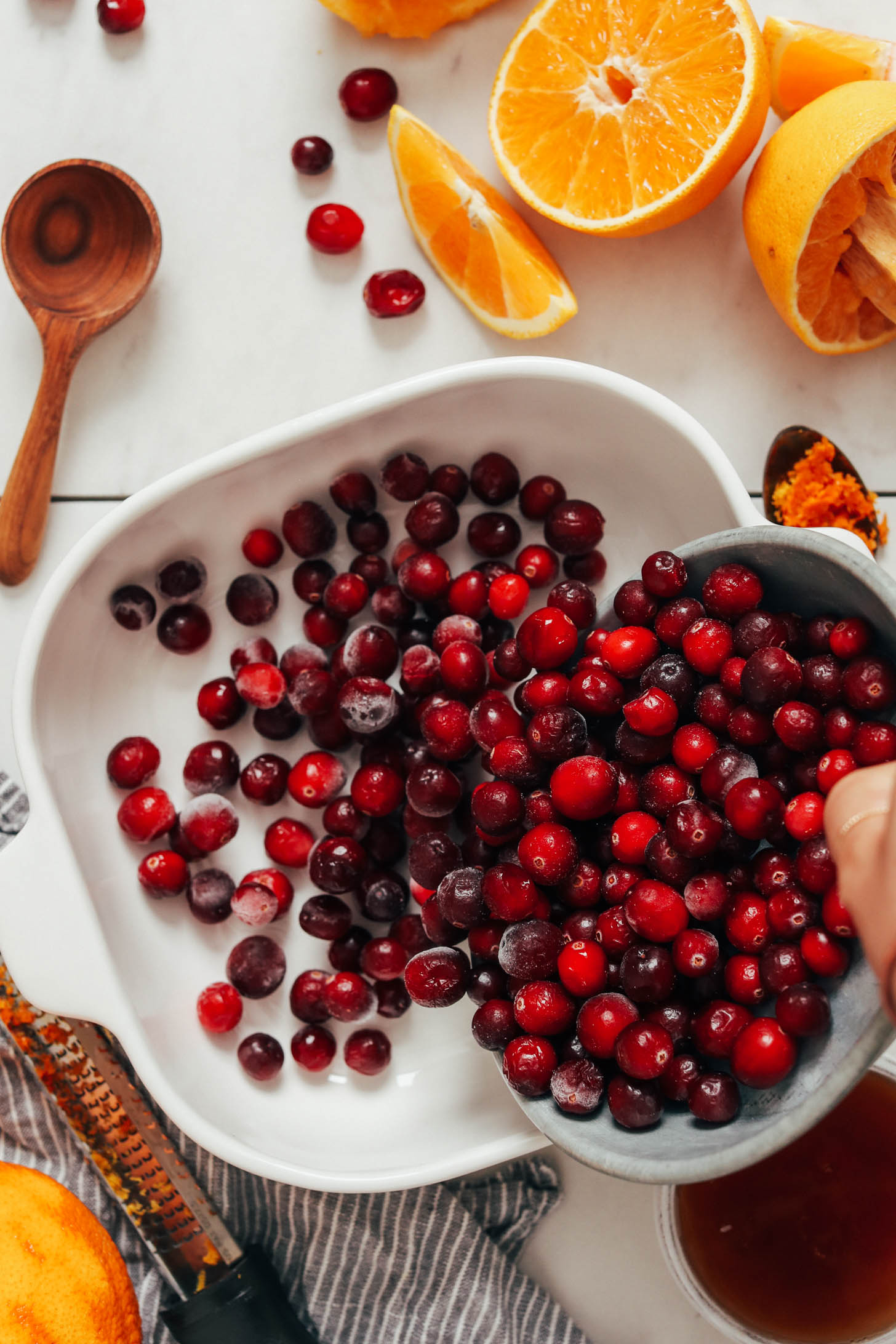 Pouring fresh cranberries into a baking dish