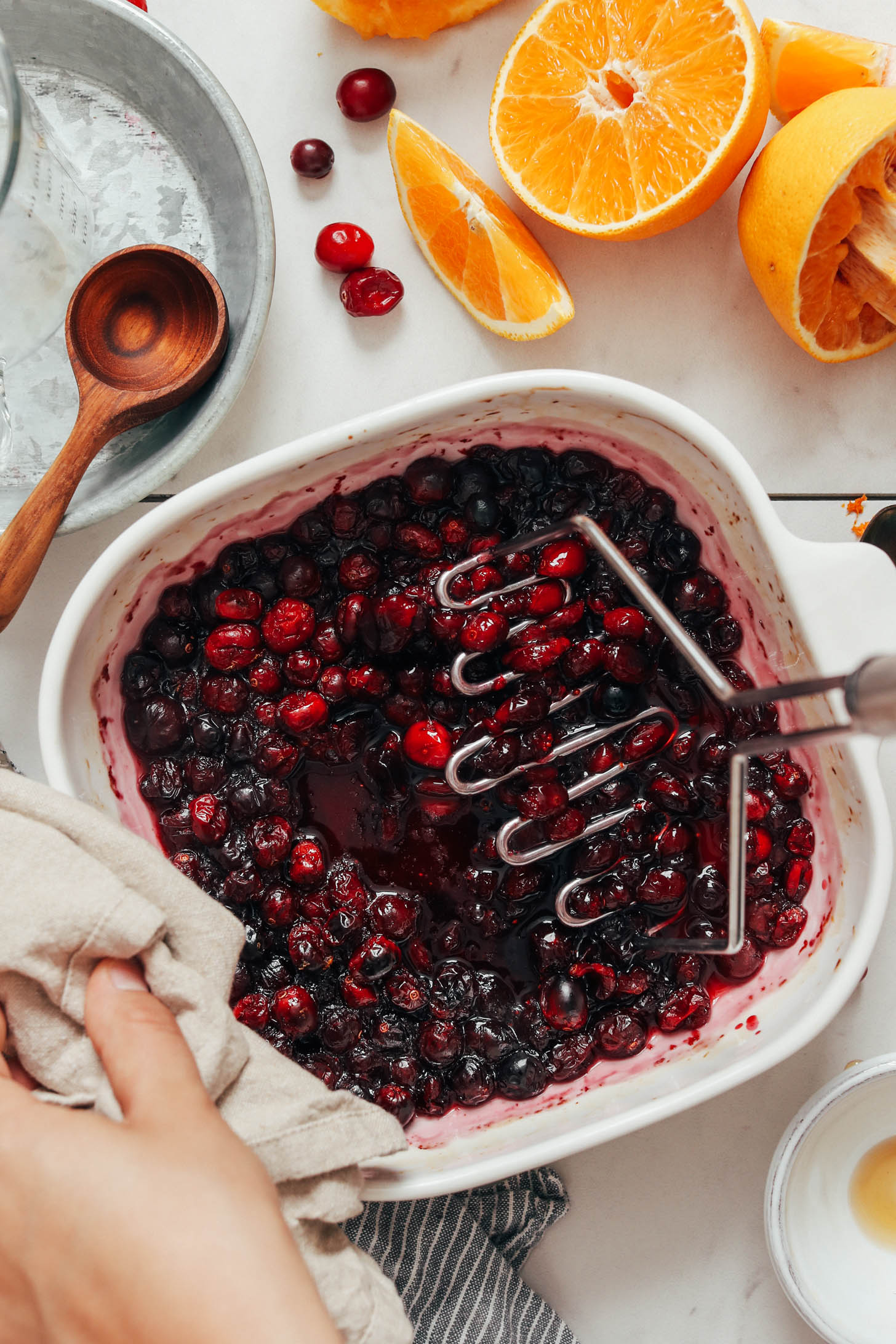 Mashing orange cranberry sauce in a baking pan