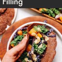 Hand holding a vegan savory teff crepe with miso squash filling