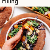 Hand holding a savory teff crepe with miso squash filling