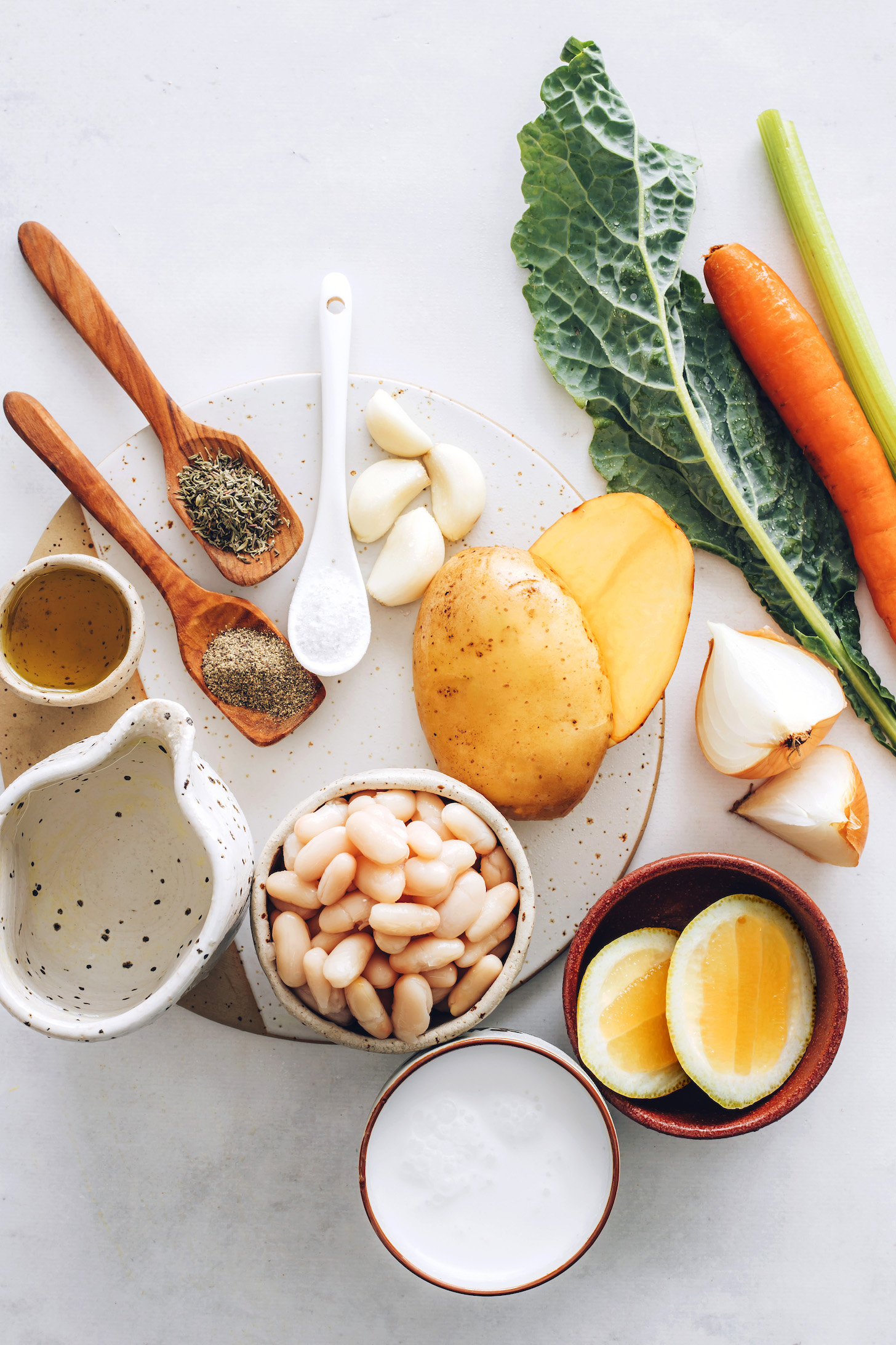 Kale, celery, carrot, onion, potato, lemon, coconut milk, white beans, water, olive oil, salt, pepper, garlic, and thyme