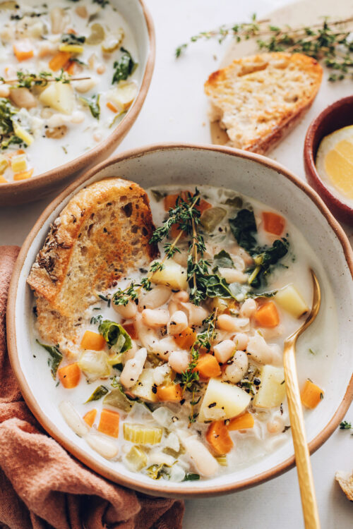 Bowl of vegan white bean soup with kale and potatoes