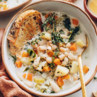 Slice of toast in a bowl of creamy white bean soup