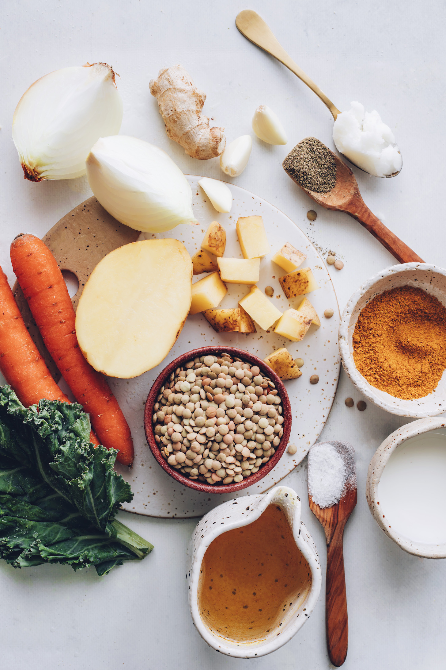 Onion, ginger, garlic, black pepper, coconut oil, curry powder, coconut milk, salt, vegetable broth, lentils, potato, carrots, and kale