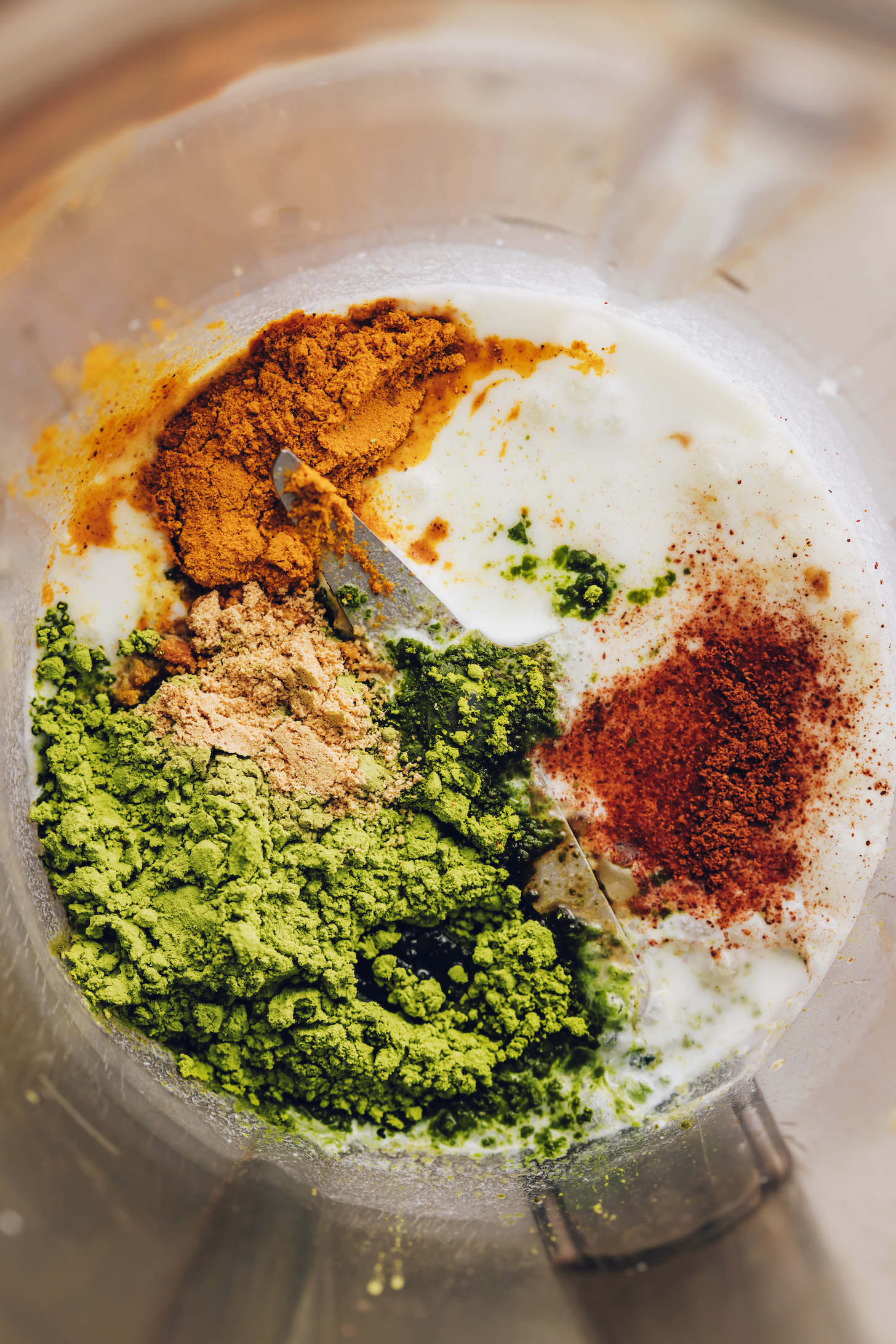 Coconut milk, water, turmeric, cinnamon, ginger, black pepper, matcha, and cardamom in a blender