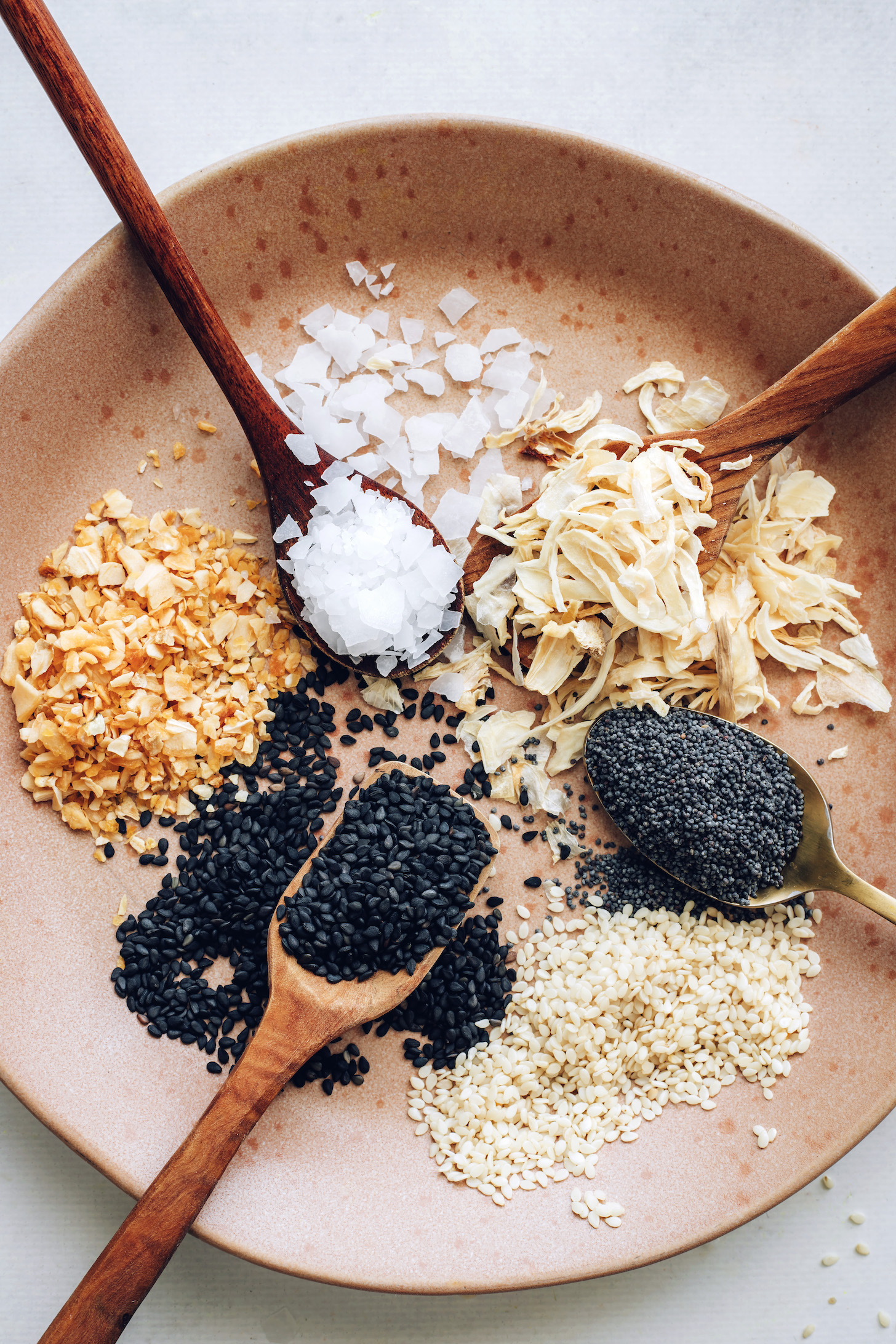 Plate of Maldon sea salt, dried onion, poppy seeds, sesame seeds, and dried garlic