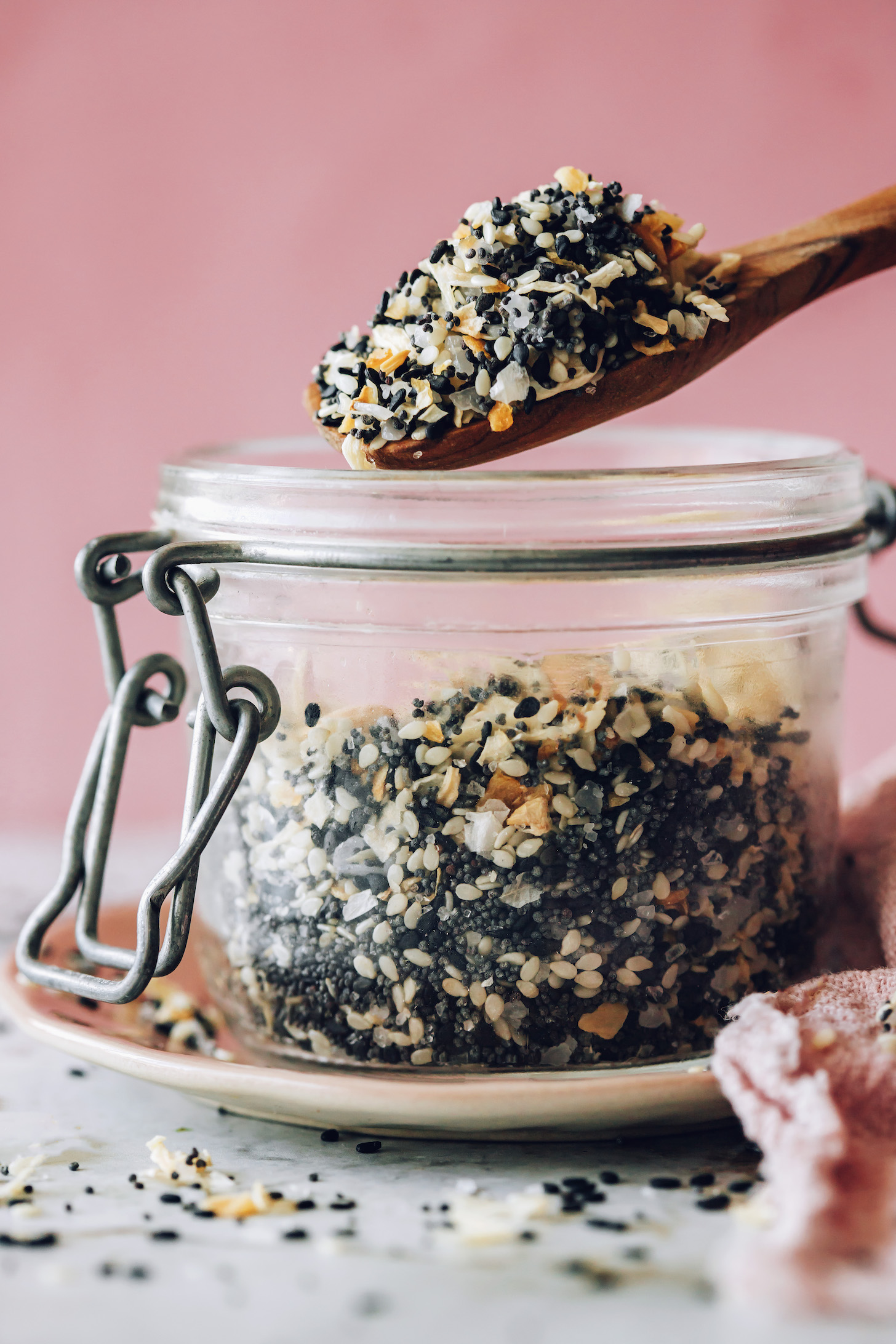 Holding a spoonful of Everything Bagel Seasoning over an open jar