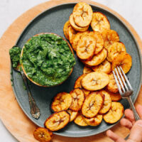 Using a fork to pick up a slice of roasted plantain