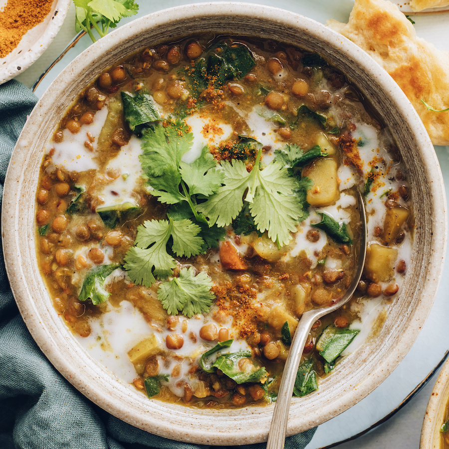 Bowl of Instant Pot lentil soup topped with cilantro and coconut milk