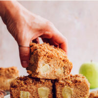 Hand holding a slice of vegan and gluten-free apple coffee cake