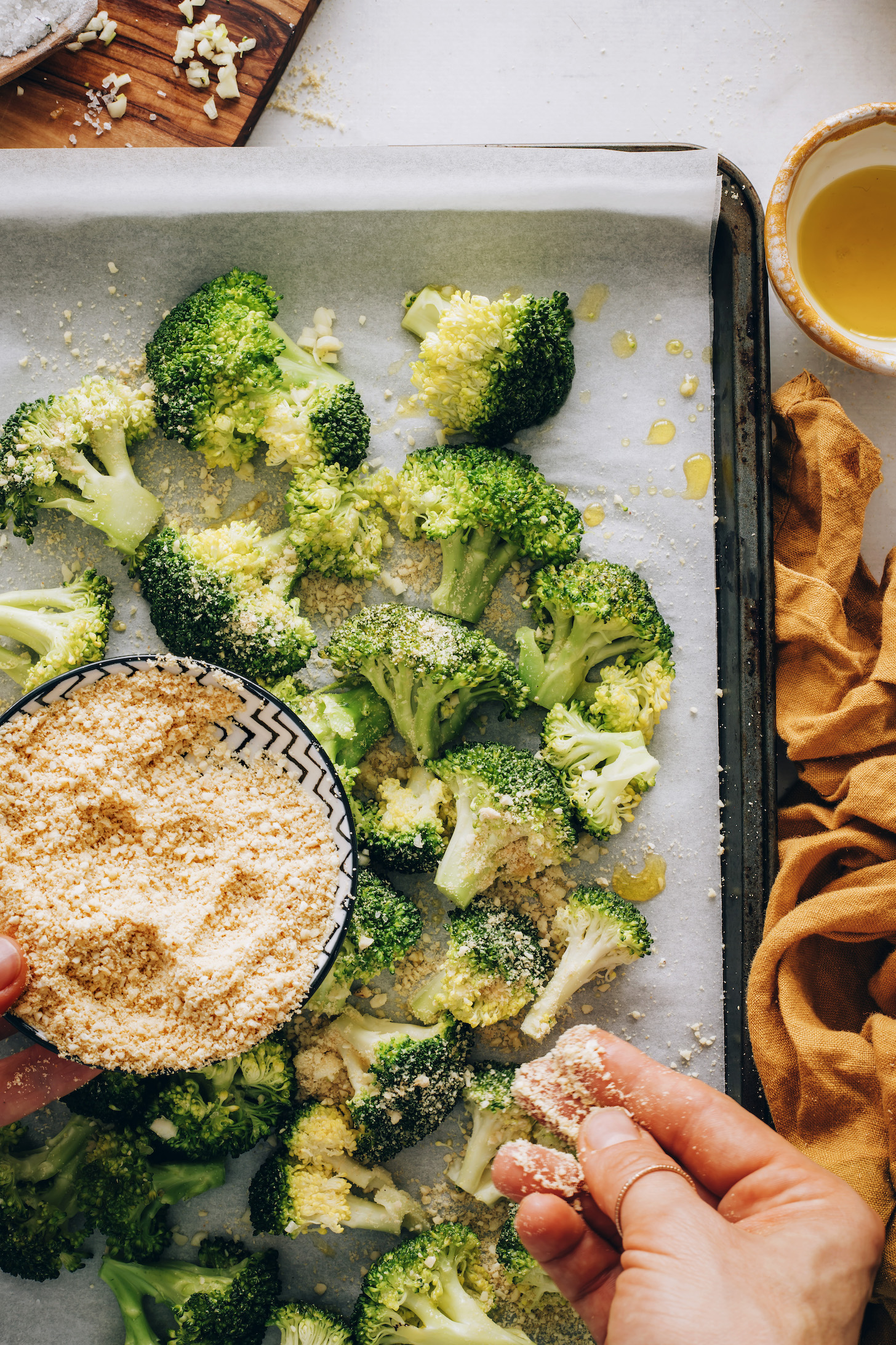 Sprinkling vegan parmesan cheese over broccoli