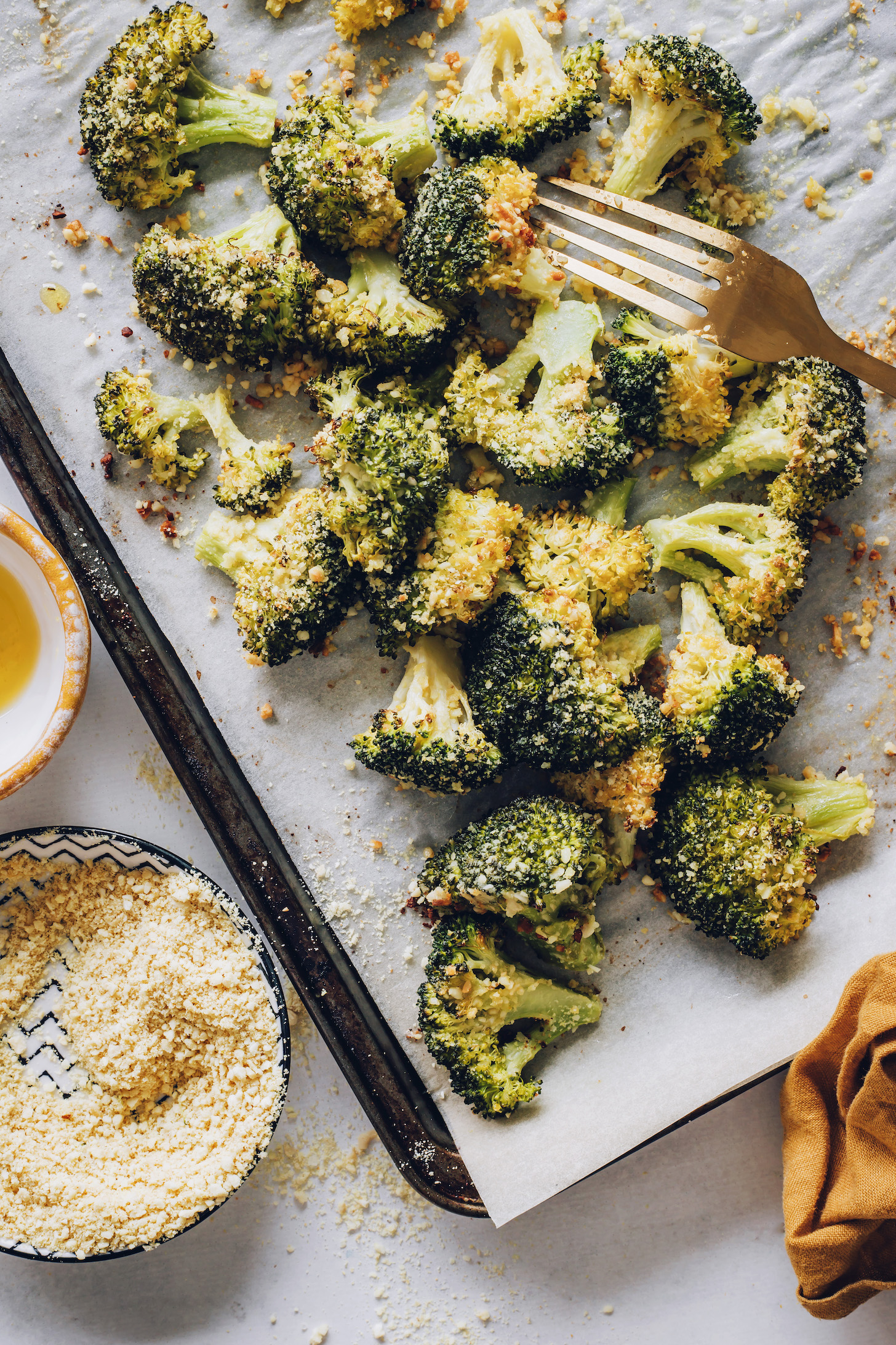 Fork resting on a baking sheet of perfectly roasted broccoli