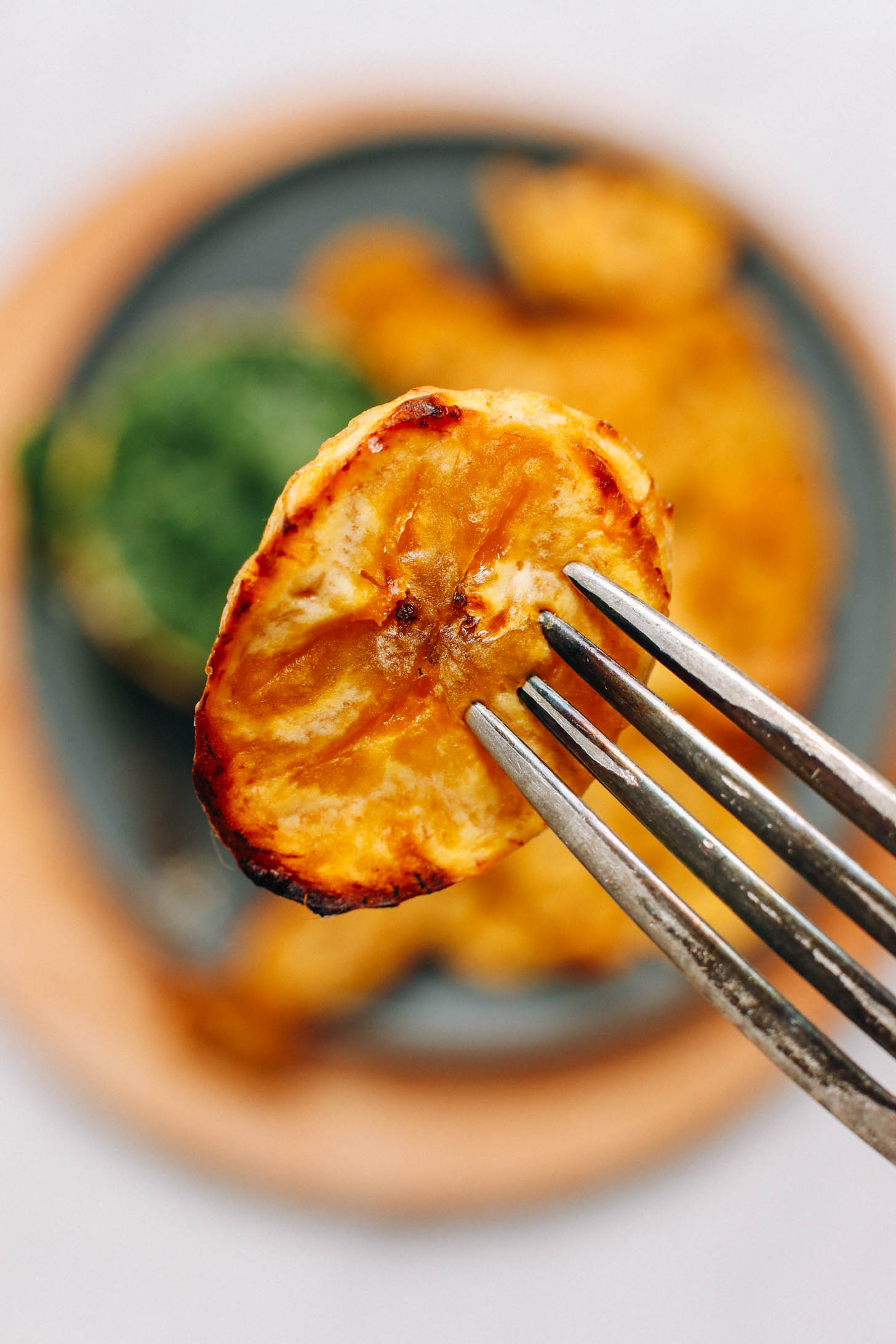 Fork holding up a piece of perfectly roasted plantain