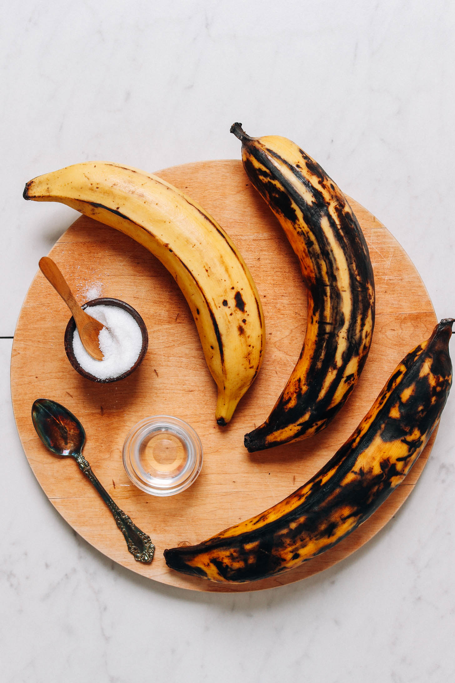 Ripe plantains, coconut oil, and salt on a cutting board