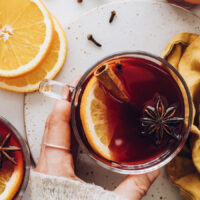 Mug of tart cherry mulled wine with orange, cinnamon, and star anise