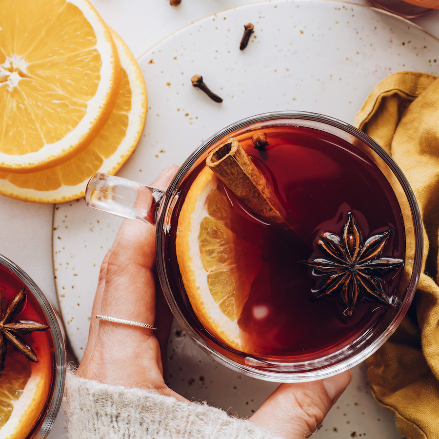Mug of tart cherry mulled wine with orange, cinnamon, and star anise