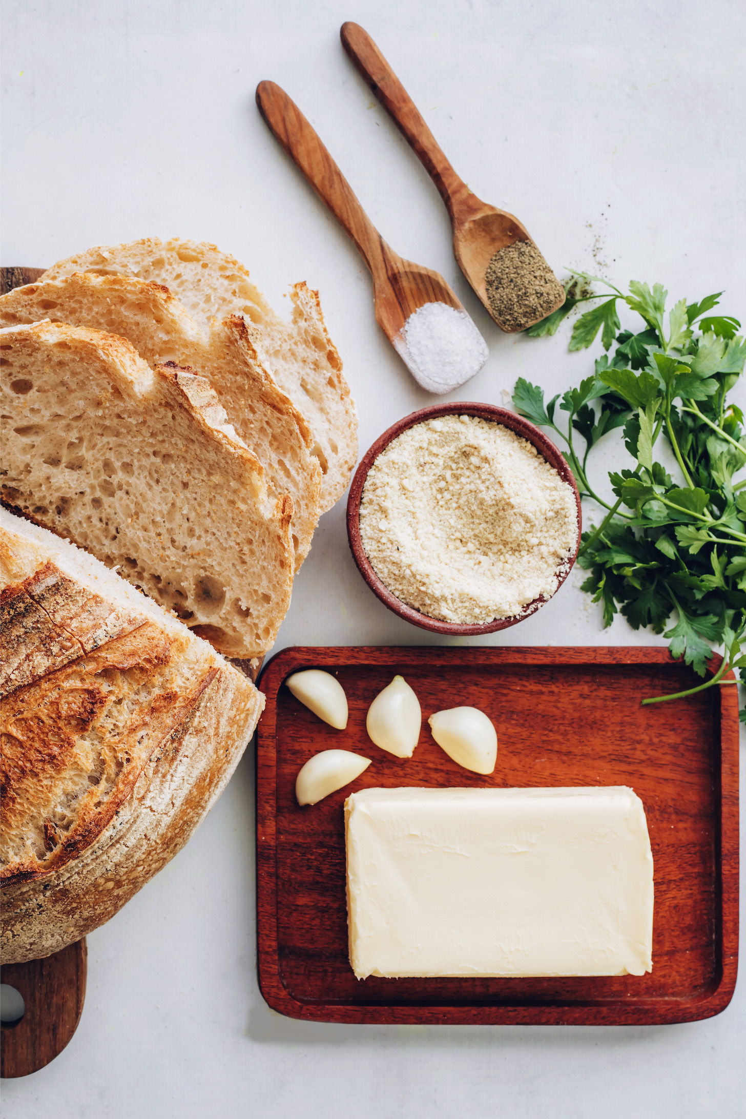 Sourdough loaf, salt, pepper, parsley, vegan parmesan cheese, garlic, and vegan butter