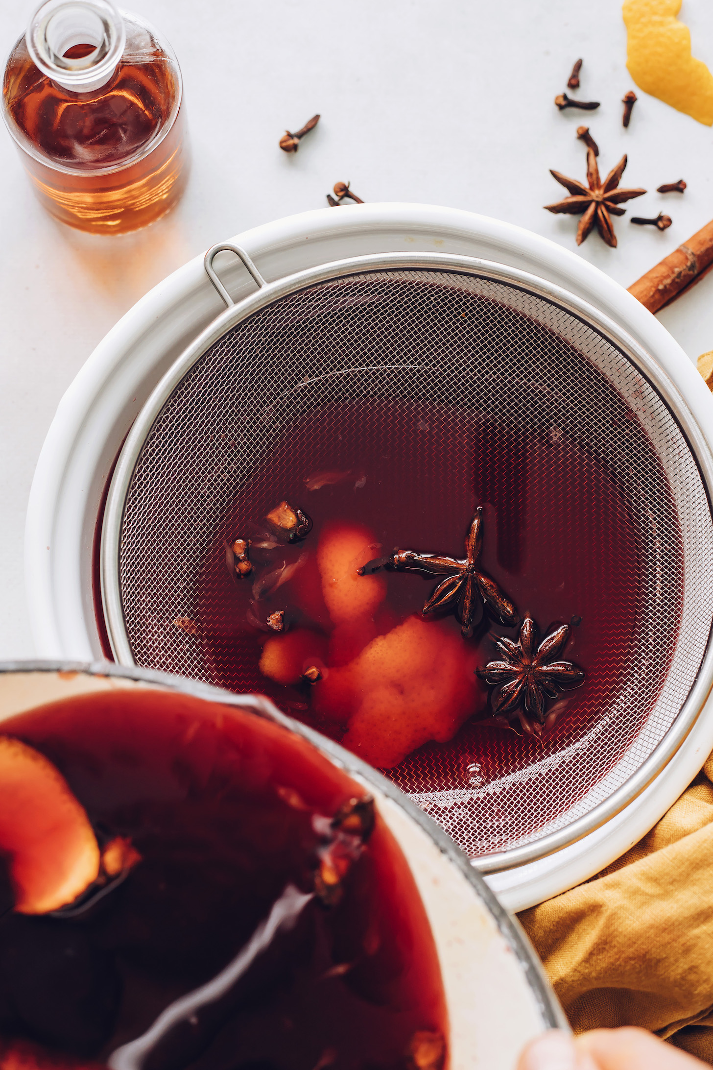 Straining mulled tart cherry juice through a fine mesh strainer