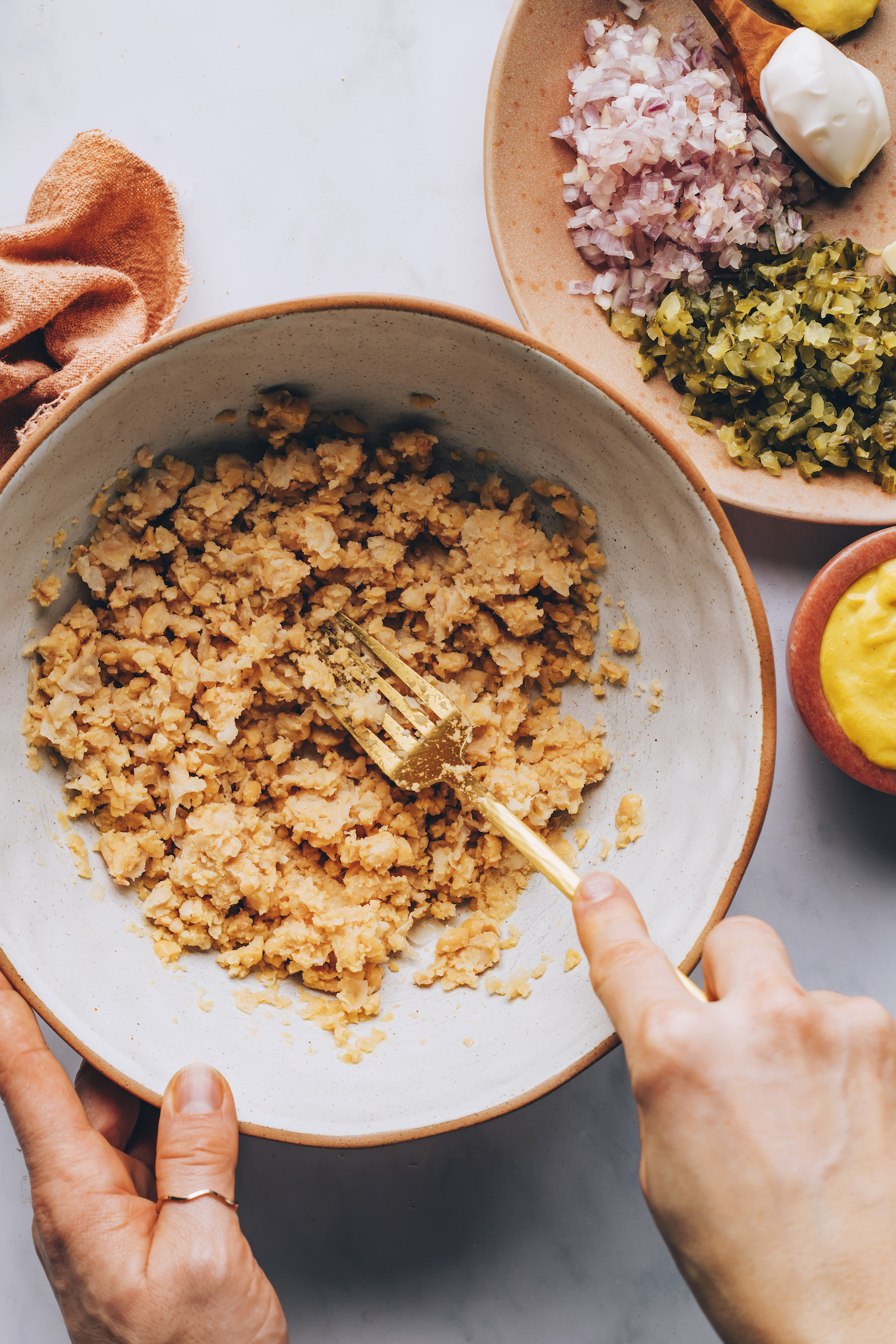 Using a fork to mash chickpeas in a bowl