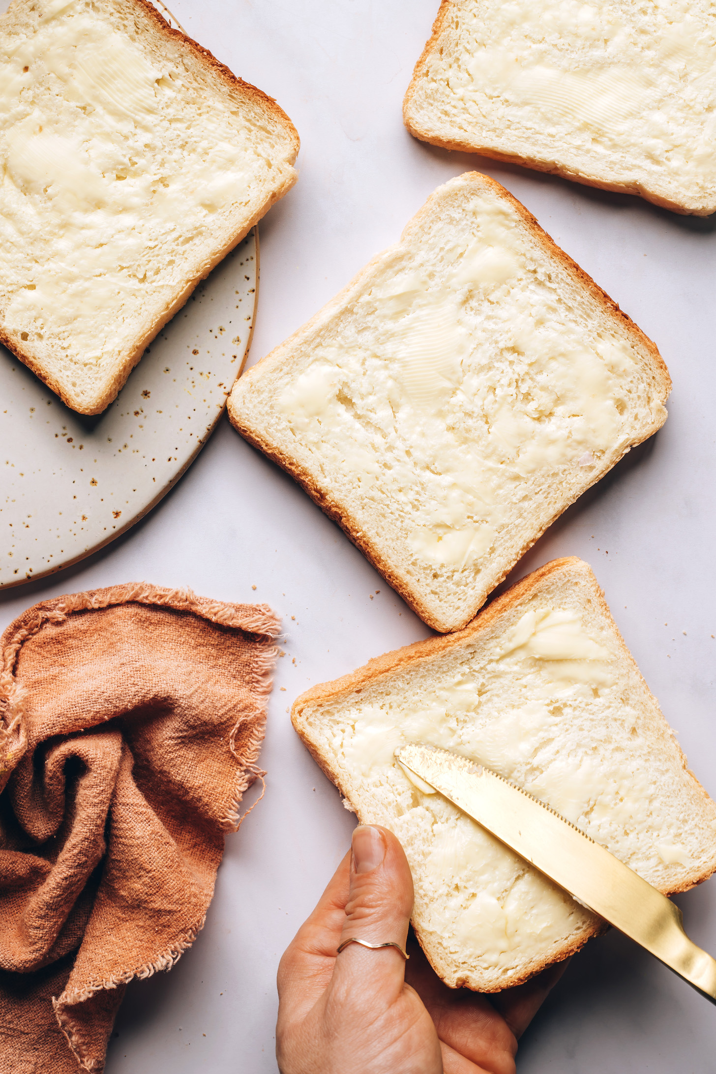 Using a butter knife to spread vegan butter on bread
