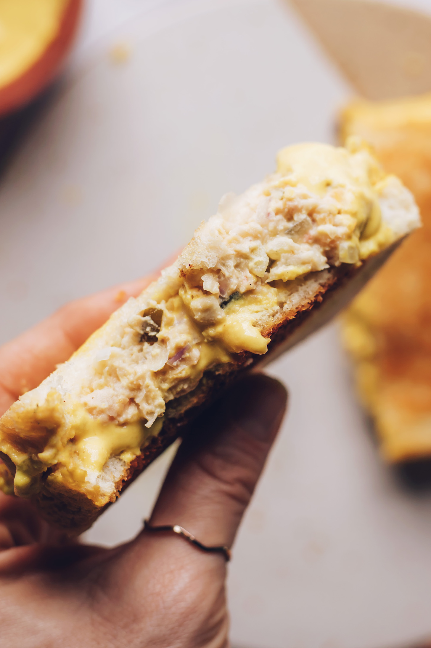 Hands holding up a vegan tuna melt