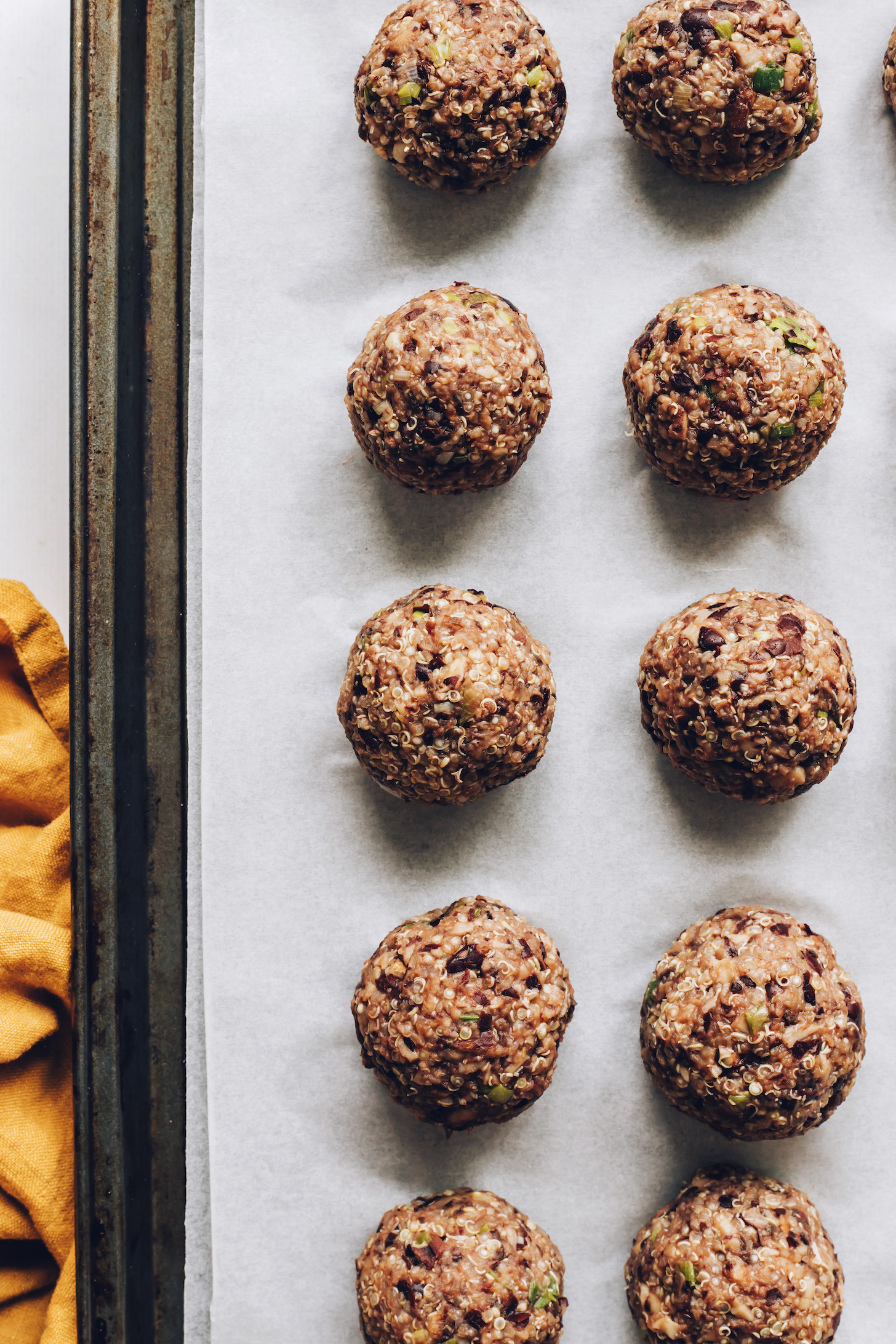 Quinoa and black bean "meatballs" on a parchment-lined baking sheet