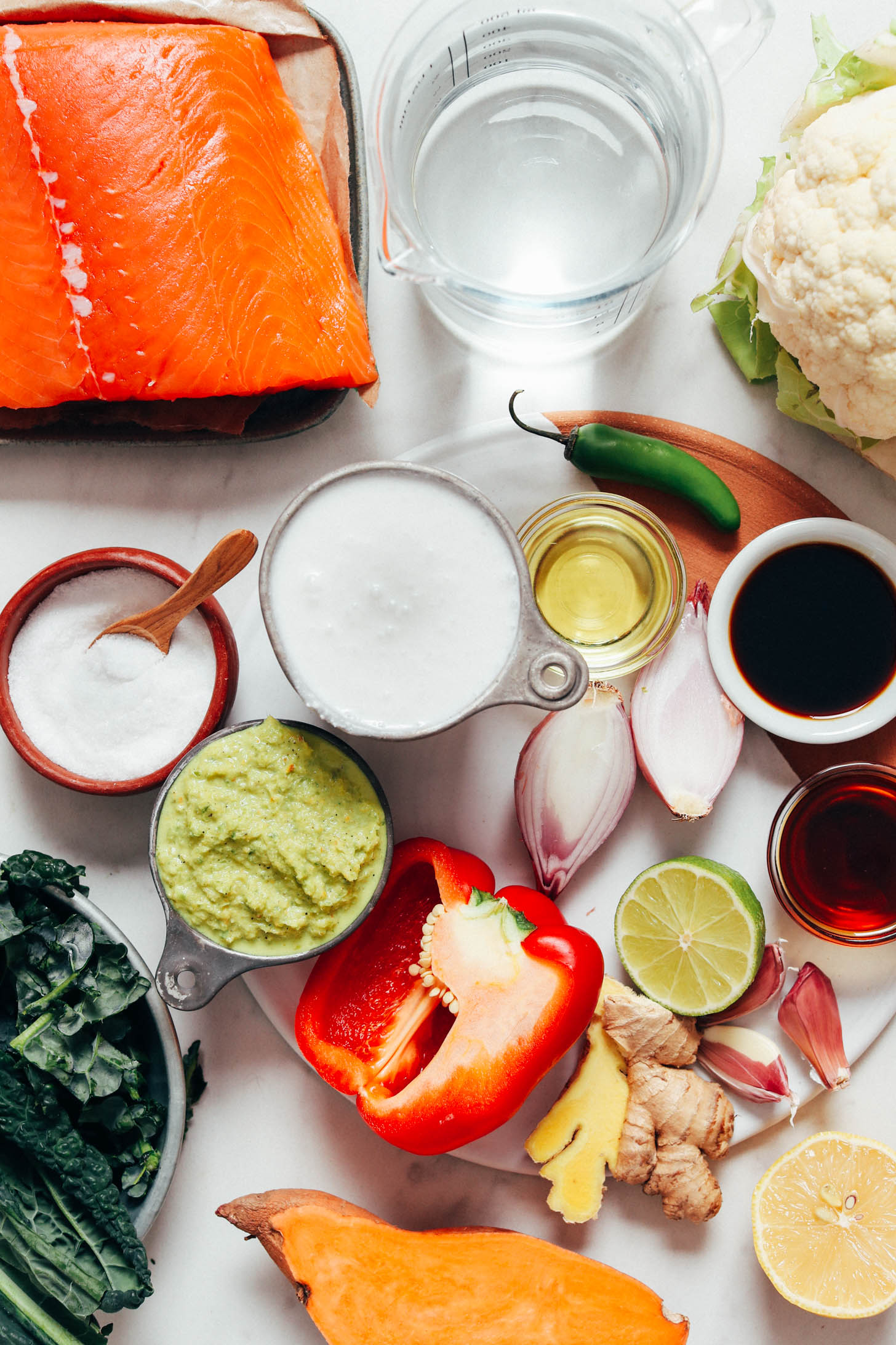 Salmon, water, cauliflower, serrano pepper, coconut milk, coconut oil, coconut aminos, maple syrup, lime, garlic, ginger, lemon, lime, sweet potato, red bell pepper, green curry paste, kale, and salt