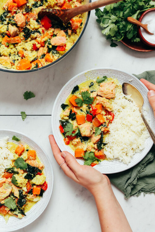 Bowls and pot of salmon green curry with vegetables