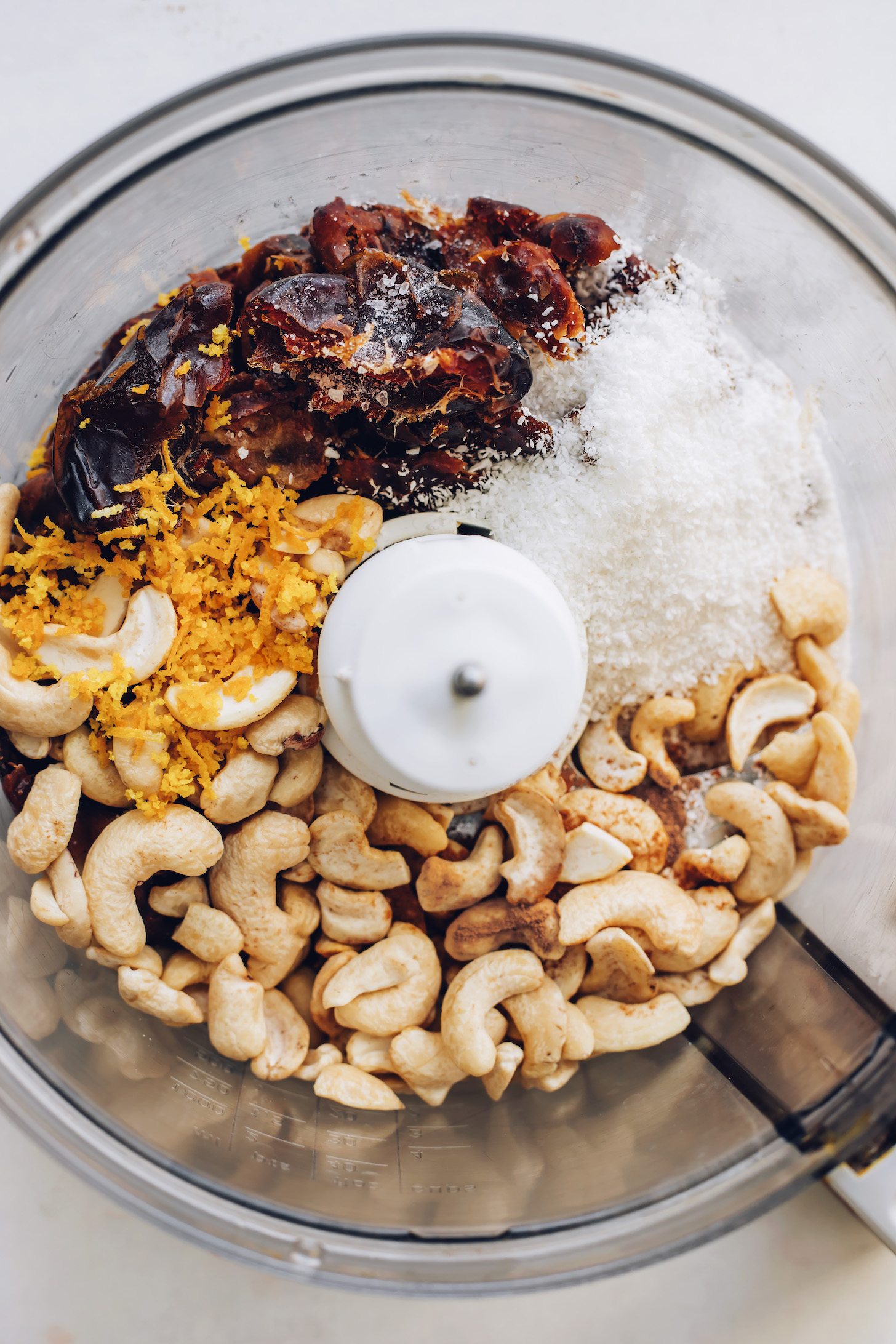 Food processor with cashews, coconut, dates, salt, and orange zest