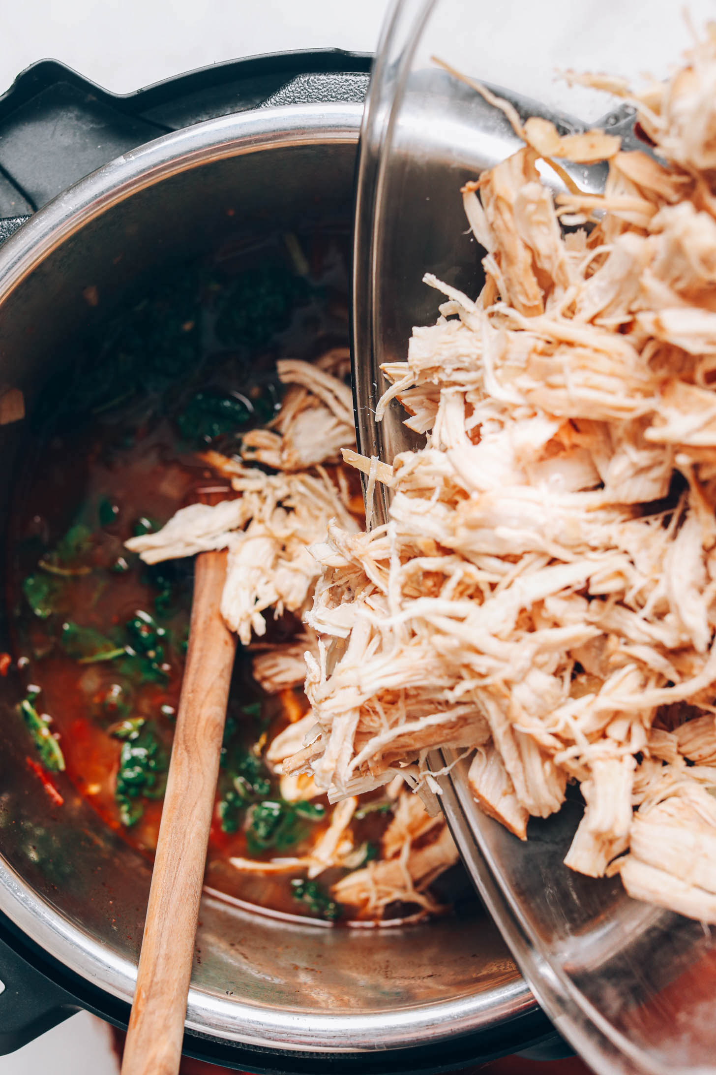Adding shredded chicken into chicken tortilla soup