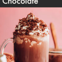 Cup of dairy-free instant hot chocolate with non-dairy whipped cream and cocoa powder on top