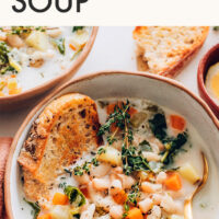 Bowl of 1-pot vegan and gluten-free white bean soup with a slice of bread in it