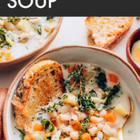 Bowl of 1-pot vegan and gluten-free white bean soup with a slice of bread in it